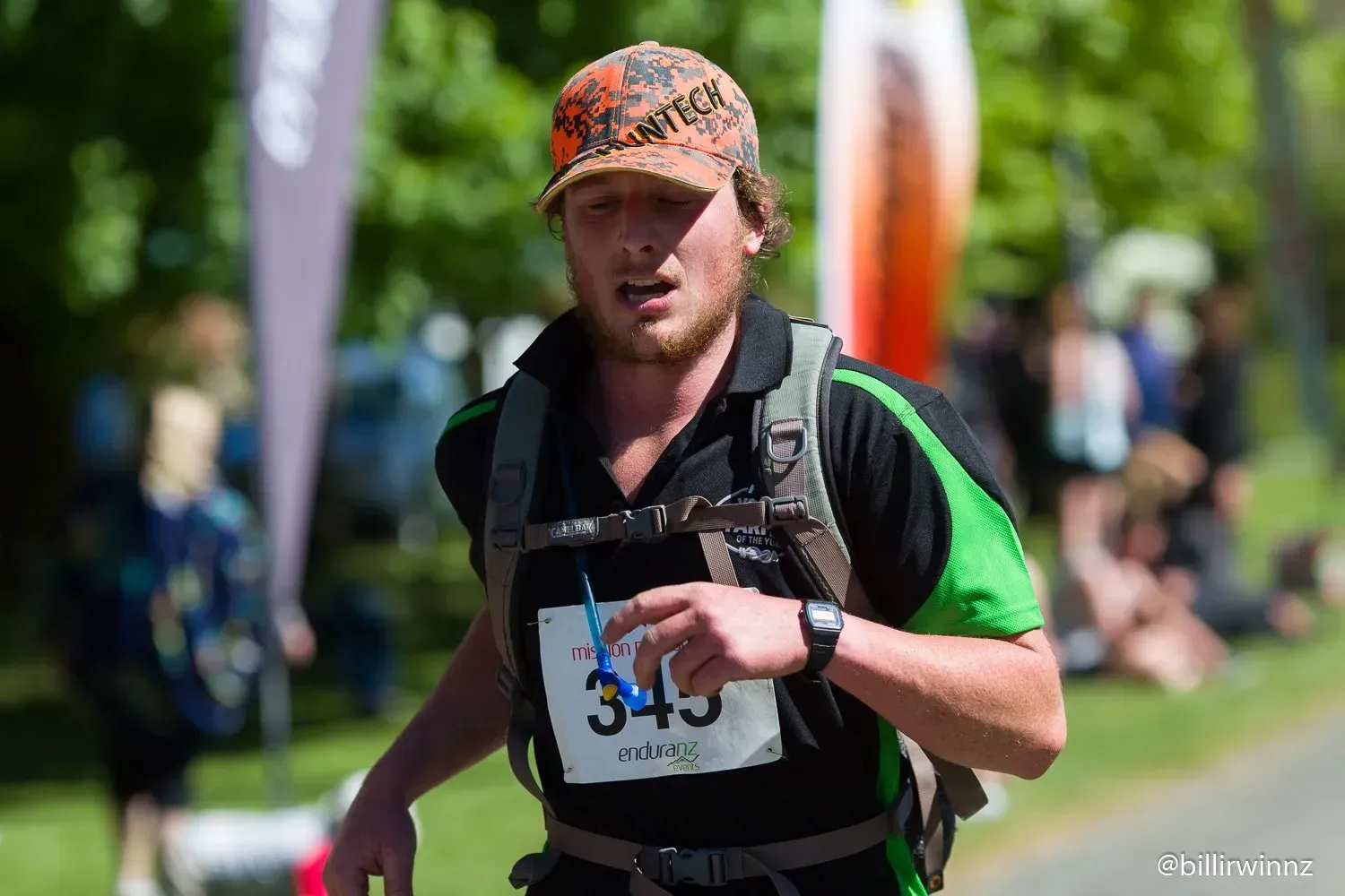 A man with a backpack is running in a race.