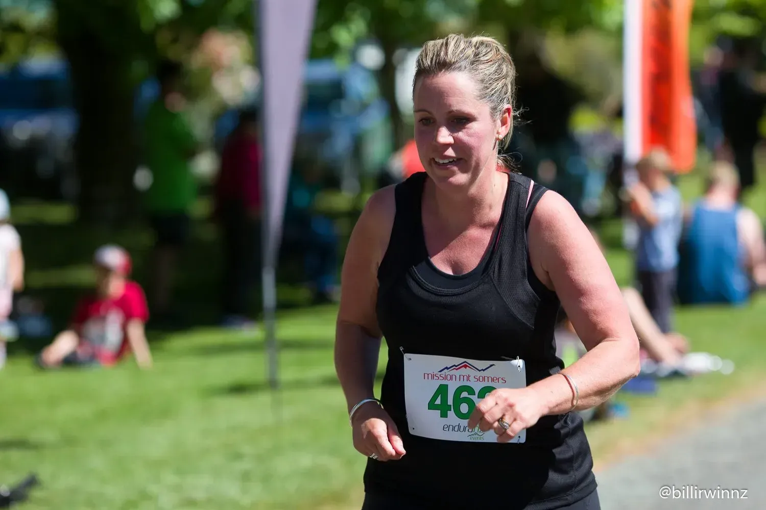 A woman is running in a race with the number 46 on her shirt.