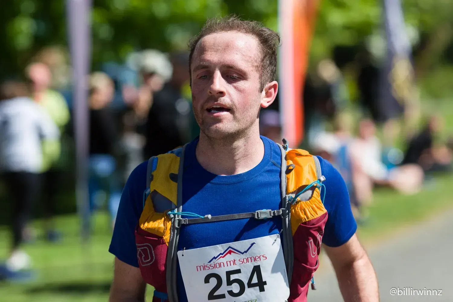 A man is running in a race with a number on his shirt.