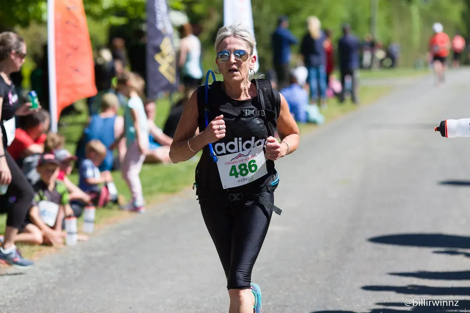 A woman is running a marathon on a road.