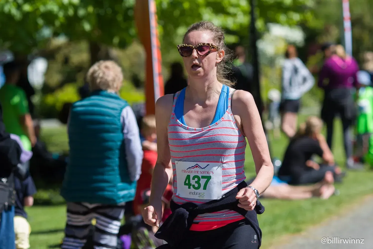 A woman is running a marathon in a park.