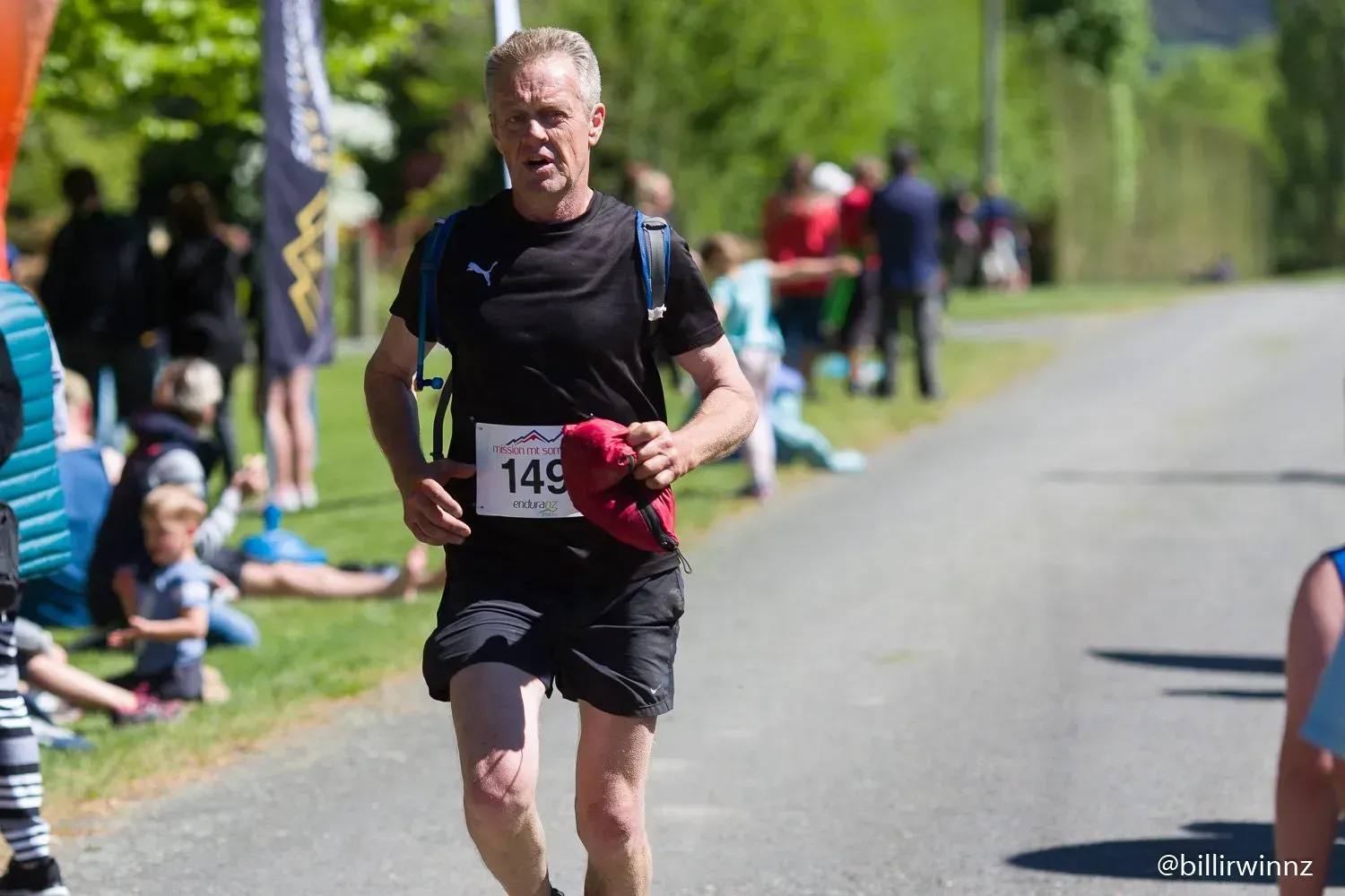 A man is running in a race with the number 149 on his shirt.