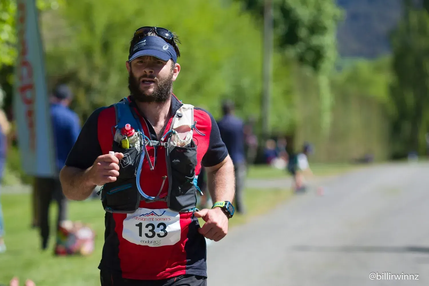 A man with a beard is running down a road.