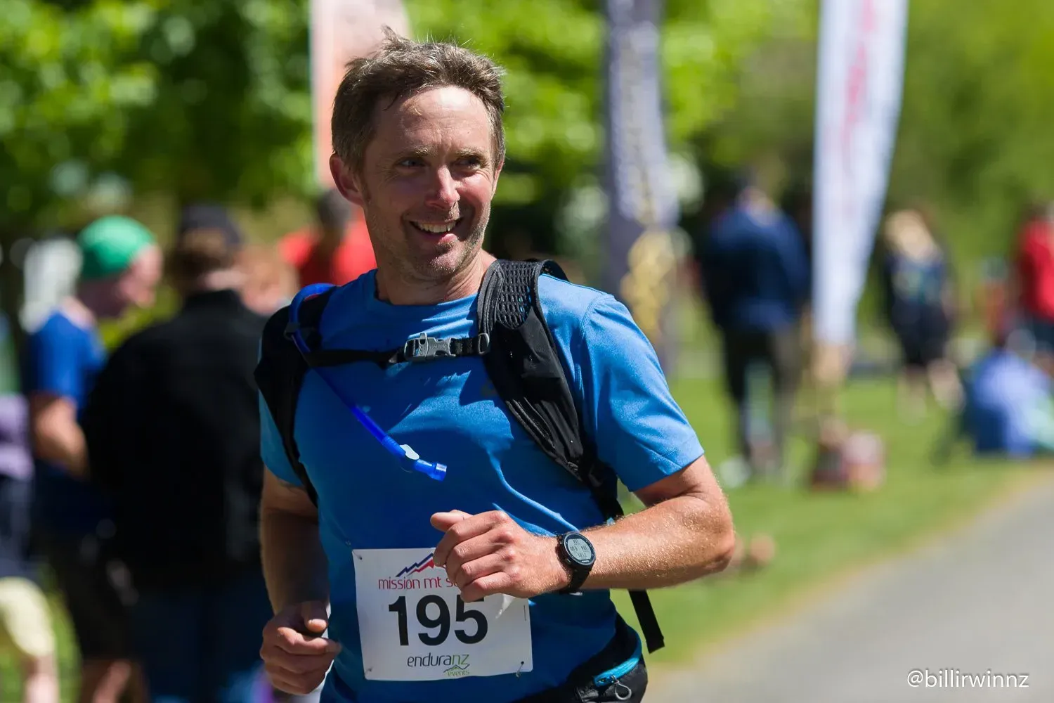 A man is running in a race with a number 195 on his shirt.