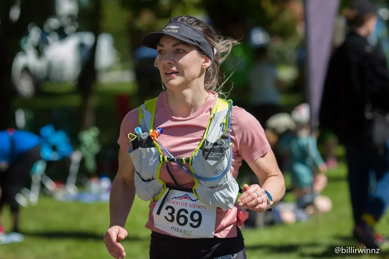 A woman is running a race in a park.