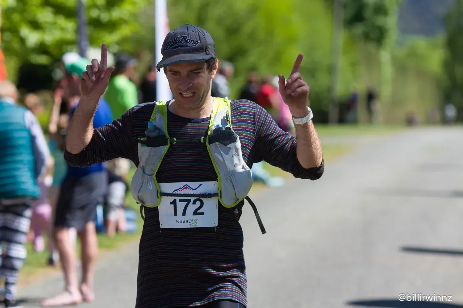 A man wearing a number 172 bib is running a race.