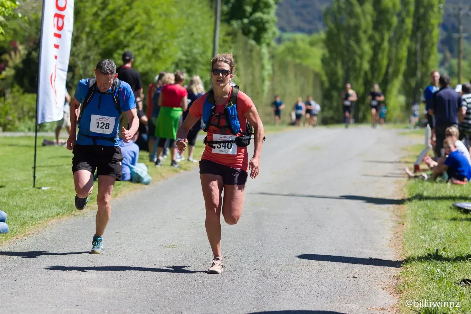 A man and a woman are running down a road.