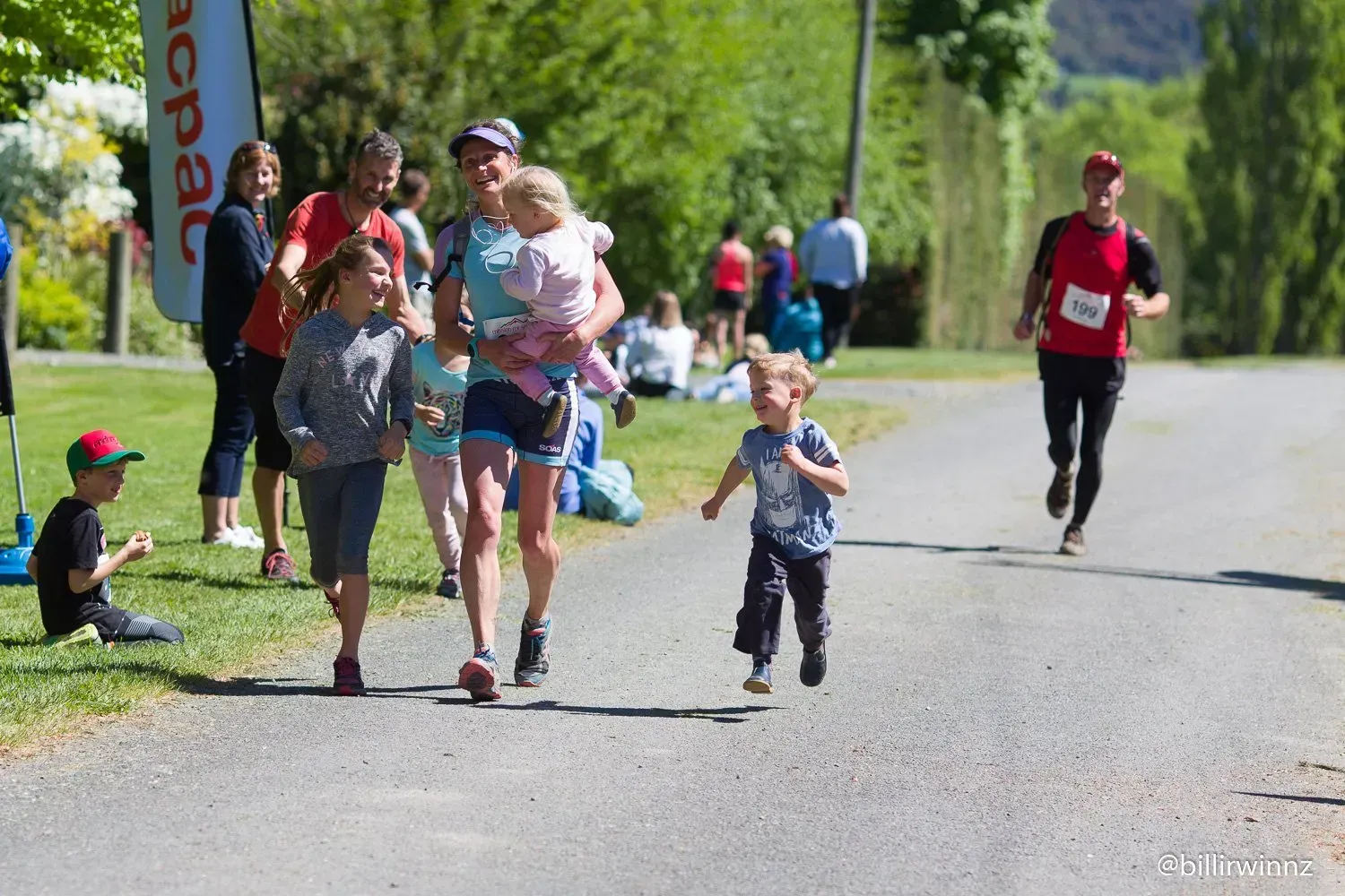 A group of people are running down a road.