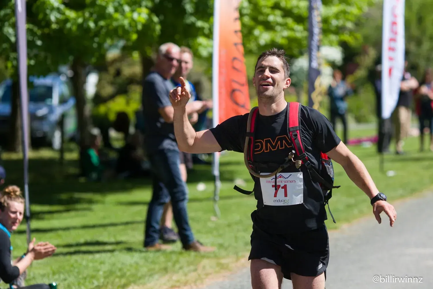 A man is running in a race and giving a high five.