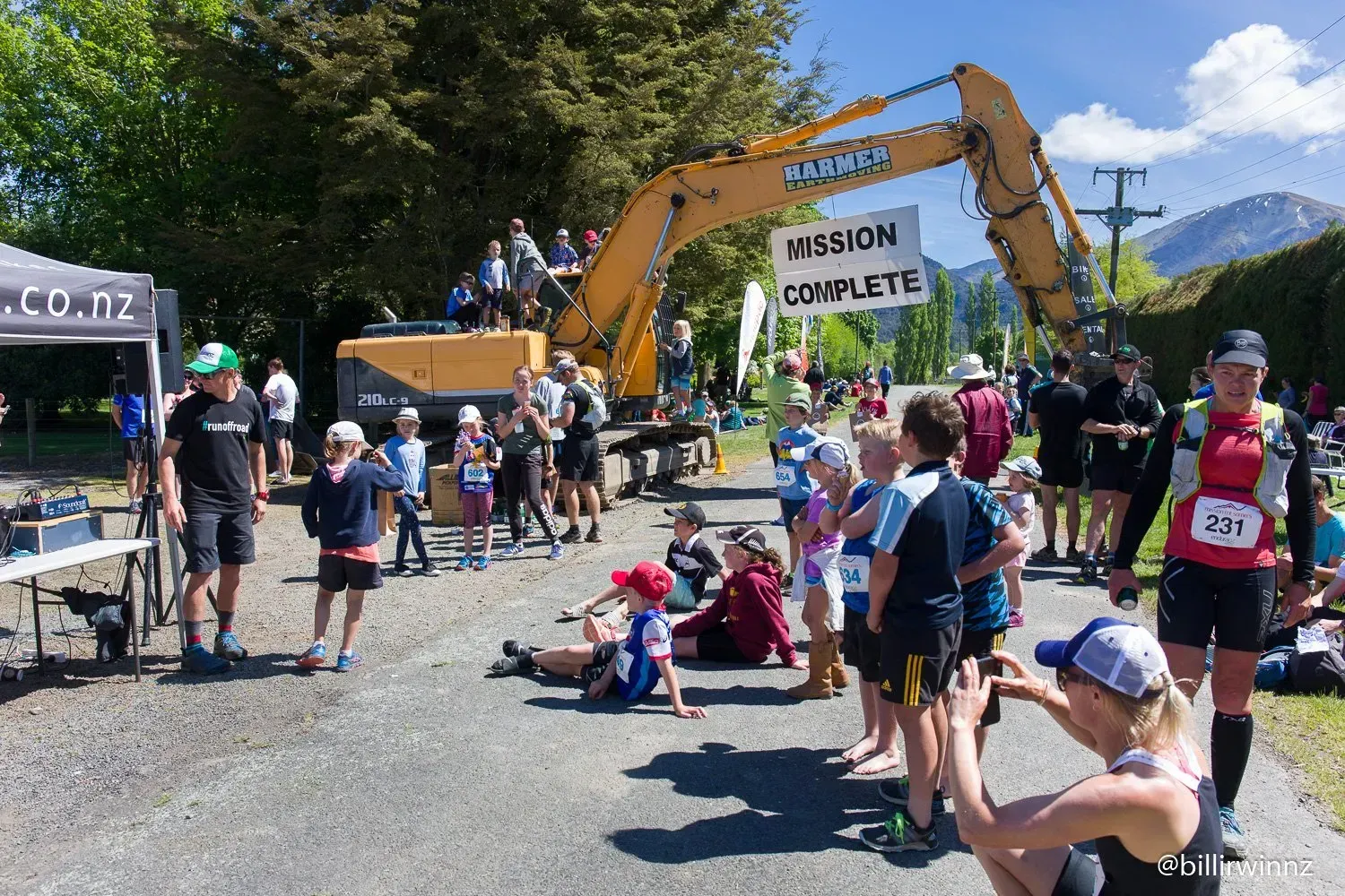 A woman is taking a picture of a group of people at a race.