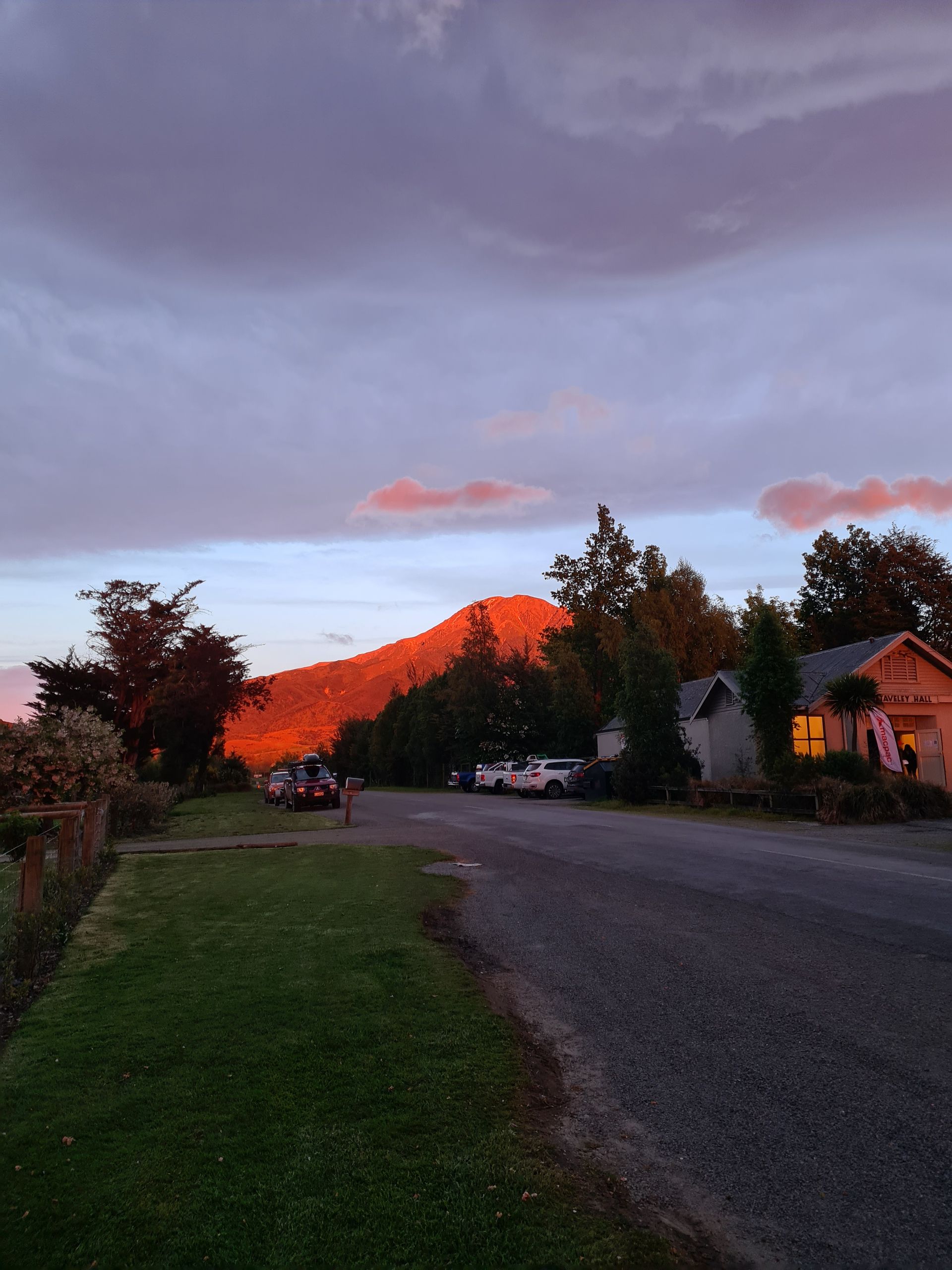 A road with a mountain in the background at sunset
