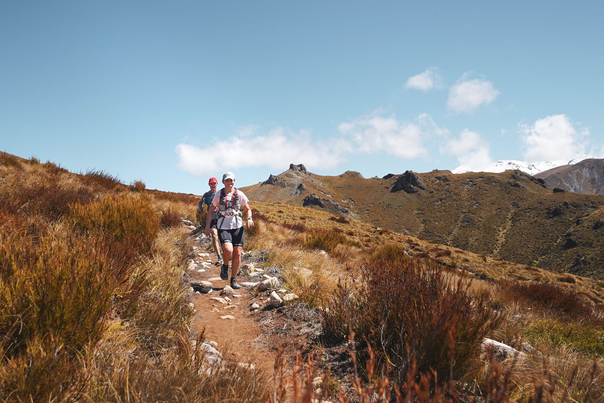 A group of people are walking down a trail in the mountains.