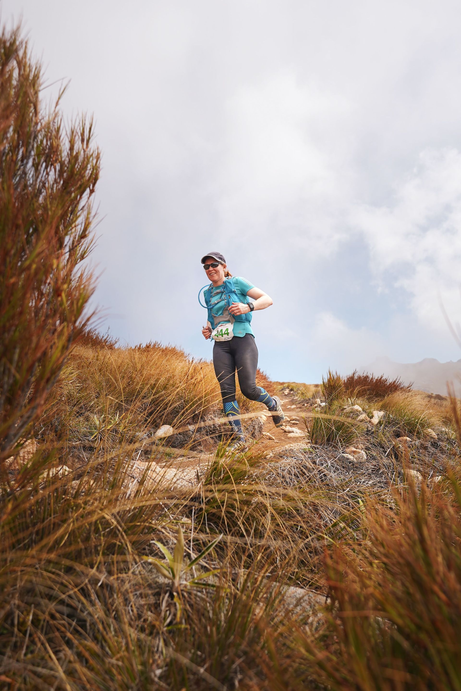 A person is running up a hill in a field.