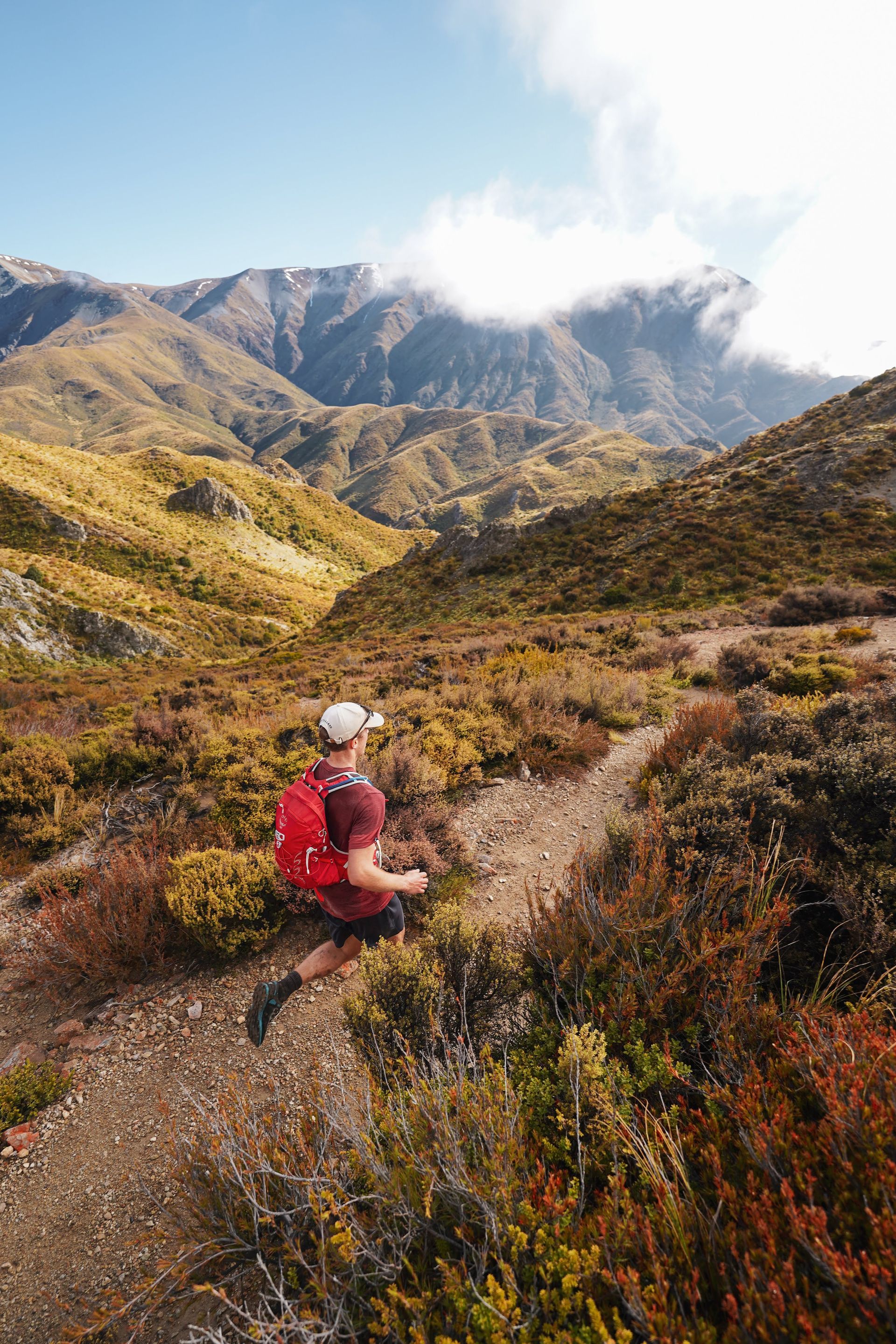 A person is running on a trail in the mountains.