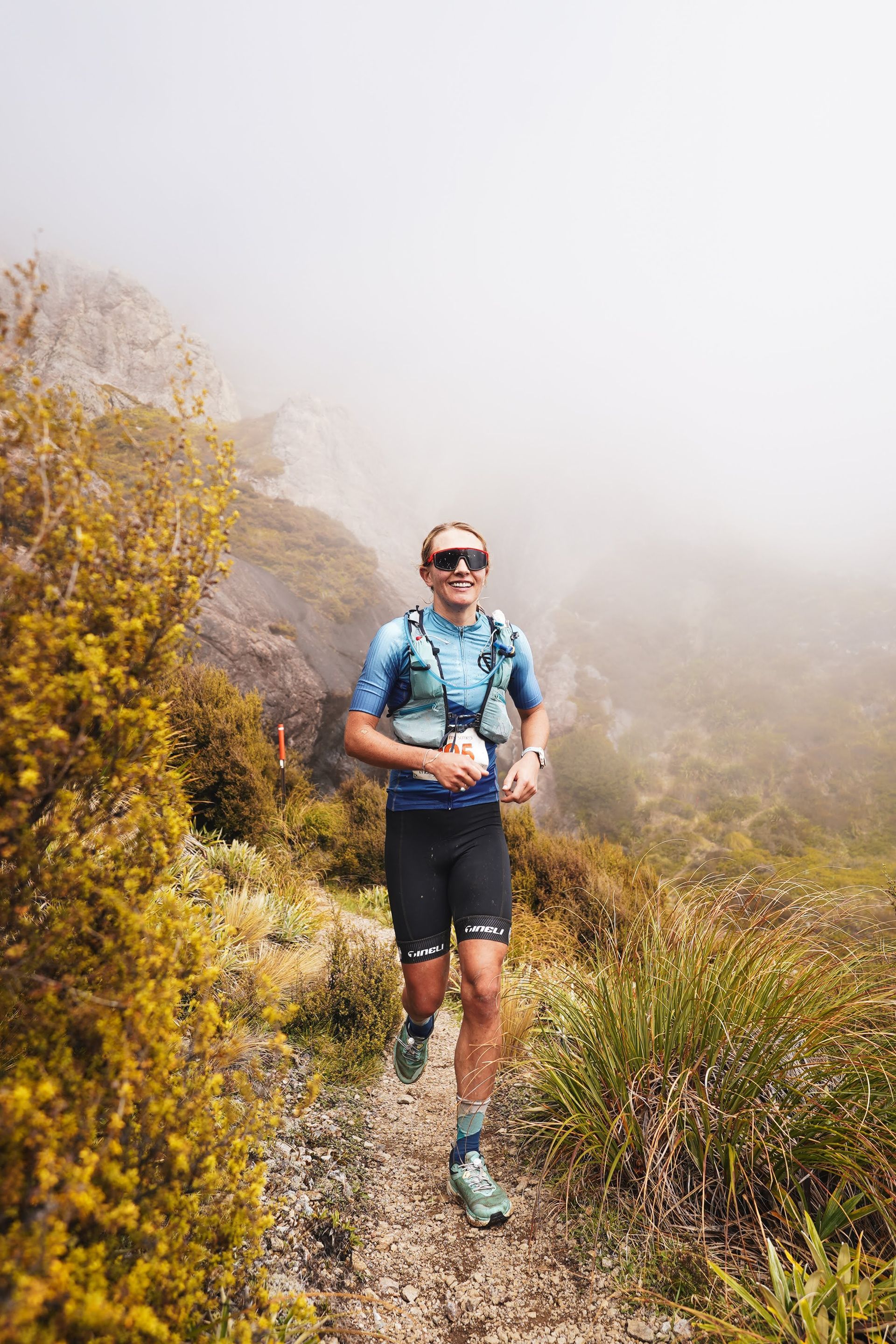 A man is running on a trail in the mountains.