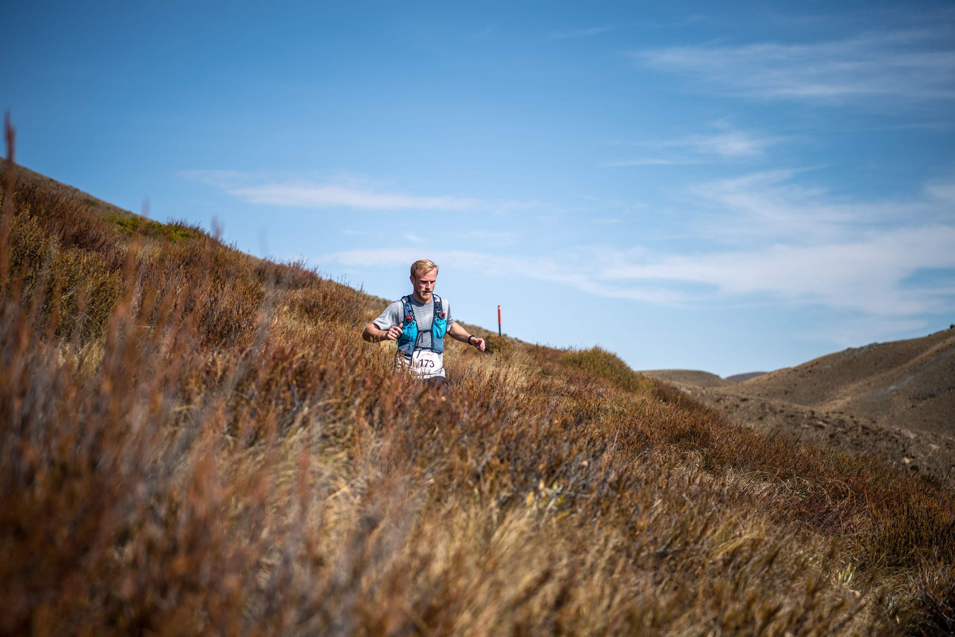 A man is running up a hill in a field.