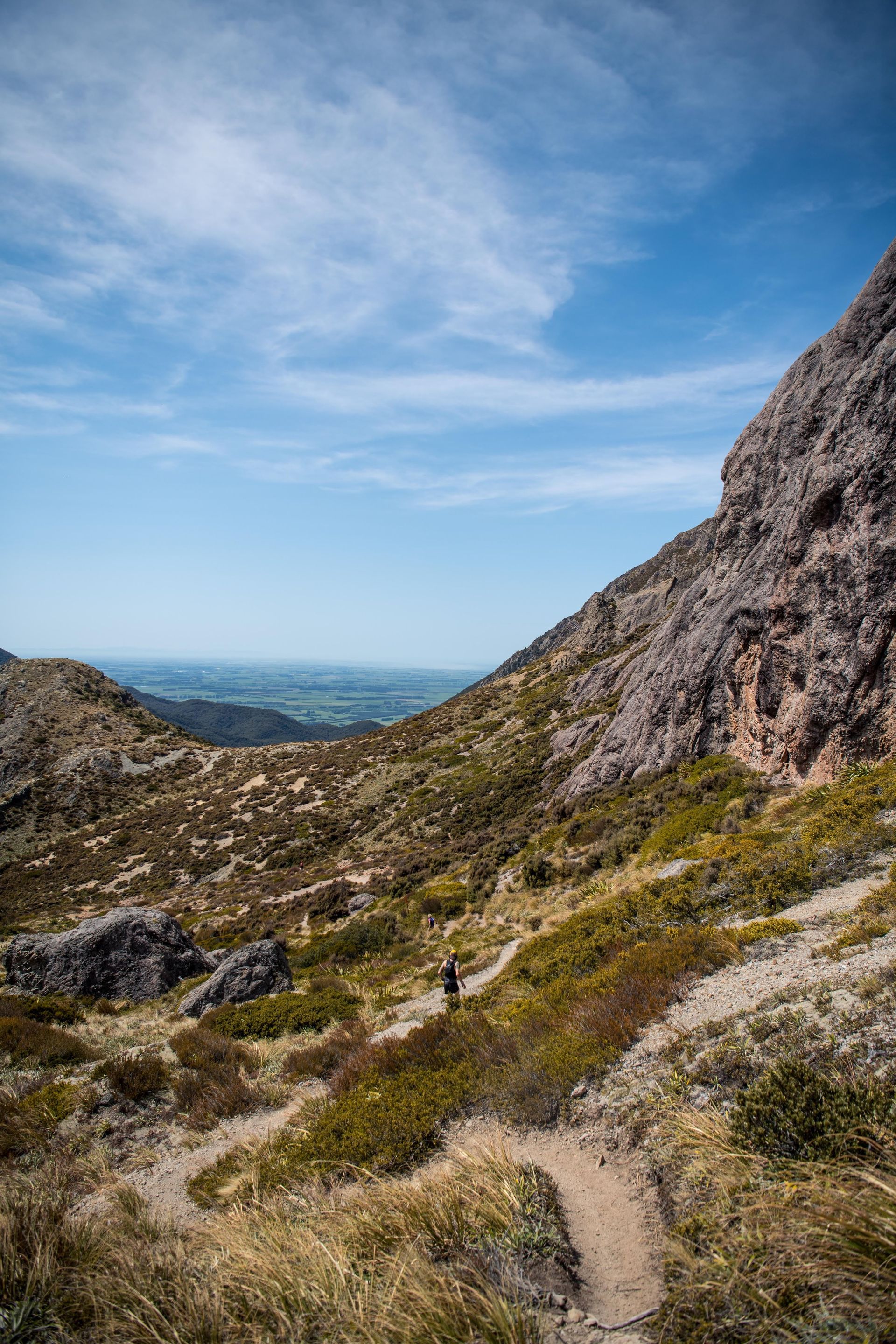 A person is walking down a trail in the mountains.