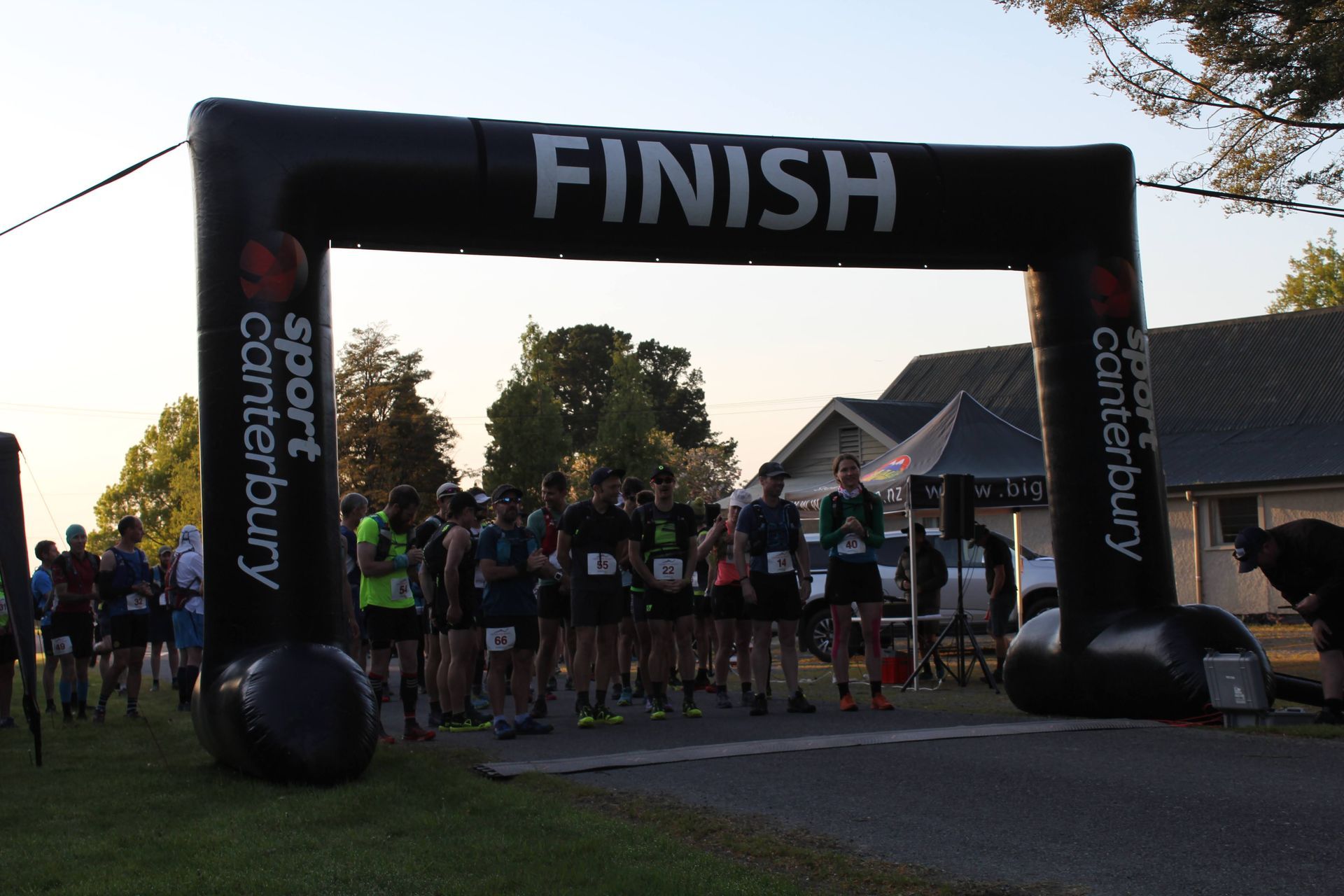 A group of people are standing under an inflatable arch that says finish.