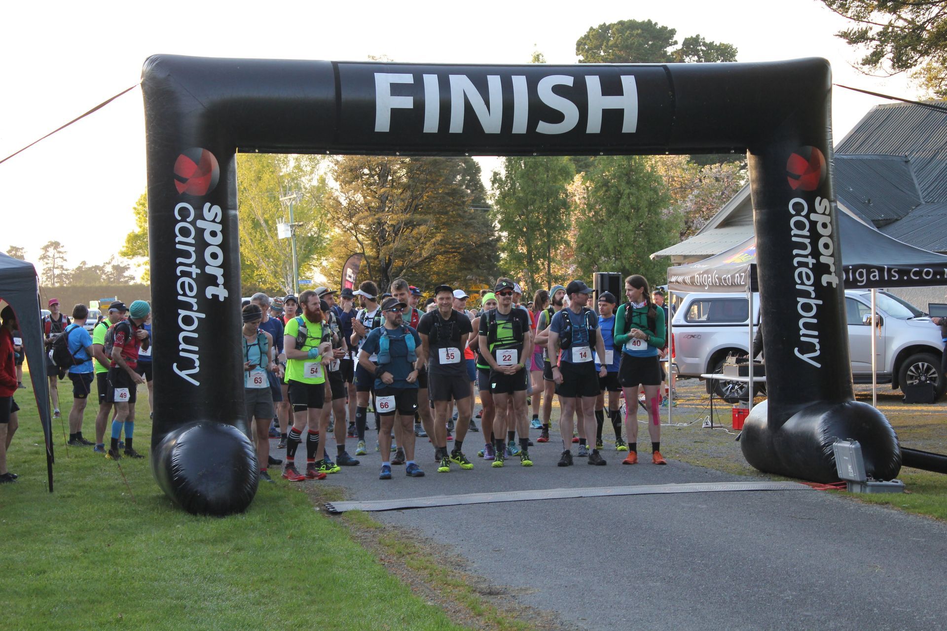 A group of people are standing under an inflatable finish arch