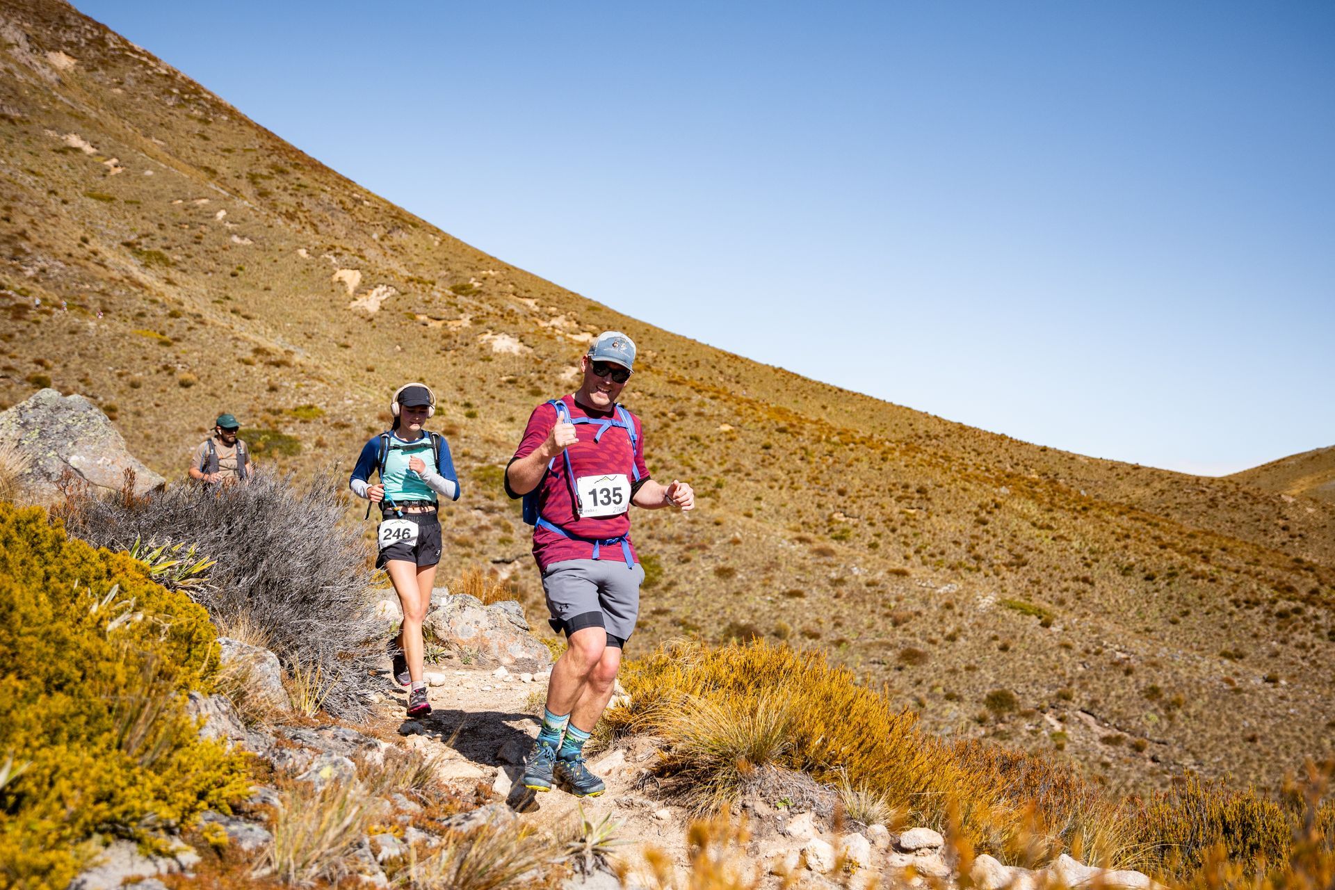 A man and a woman are running up a hill.