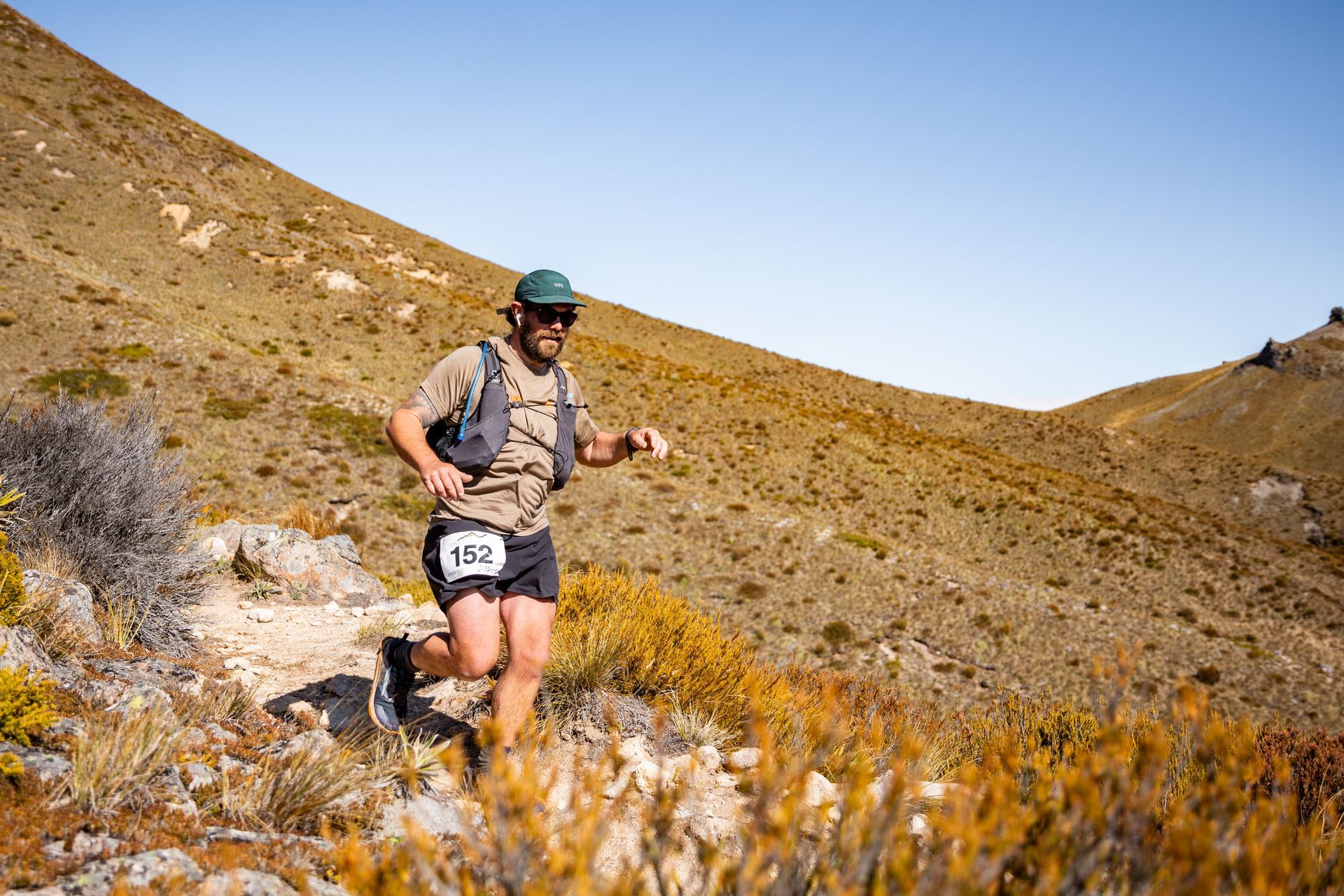 A man is running on a trail in the desert.