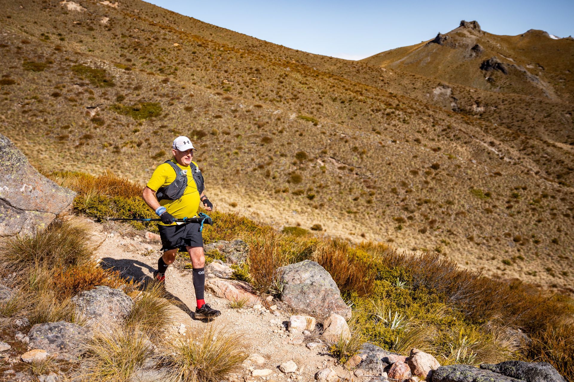 A man is running on a trail in the desert.