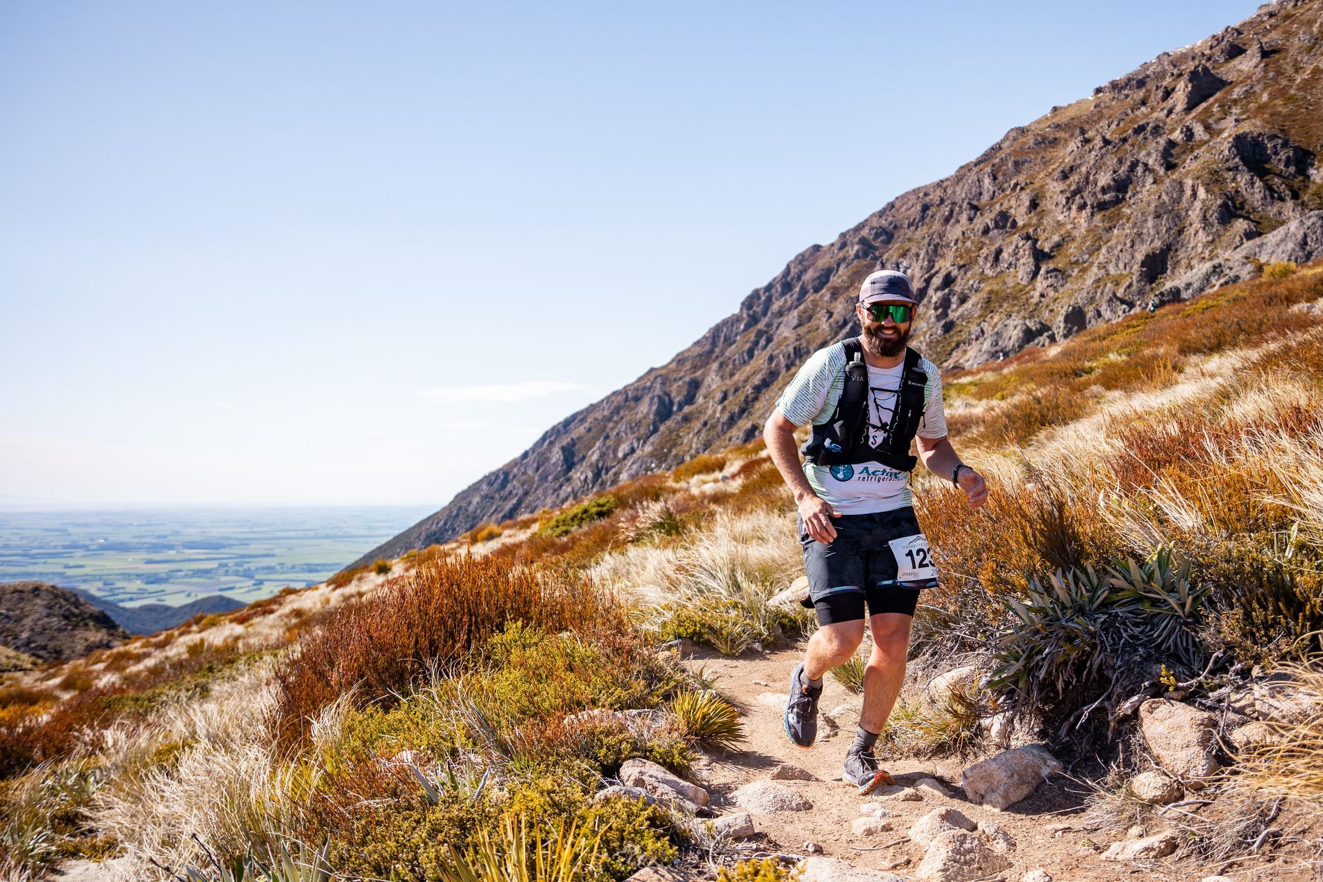 A man is running up a hill on a trail.