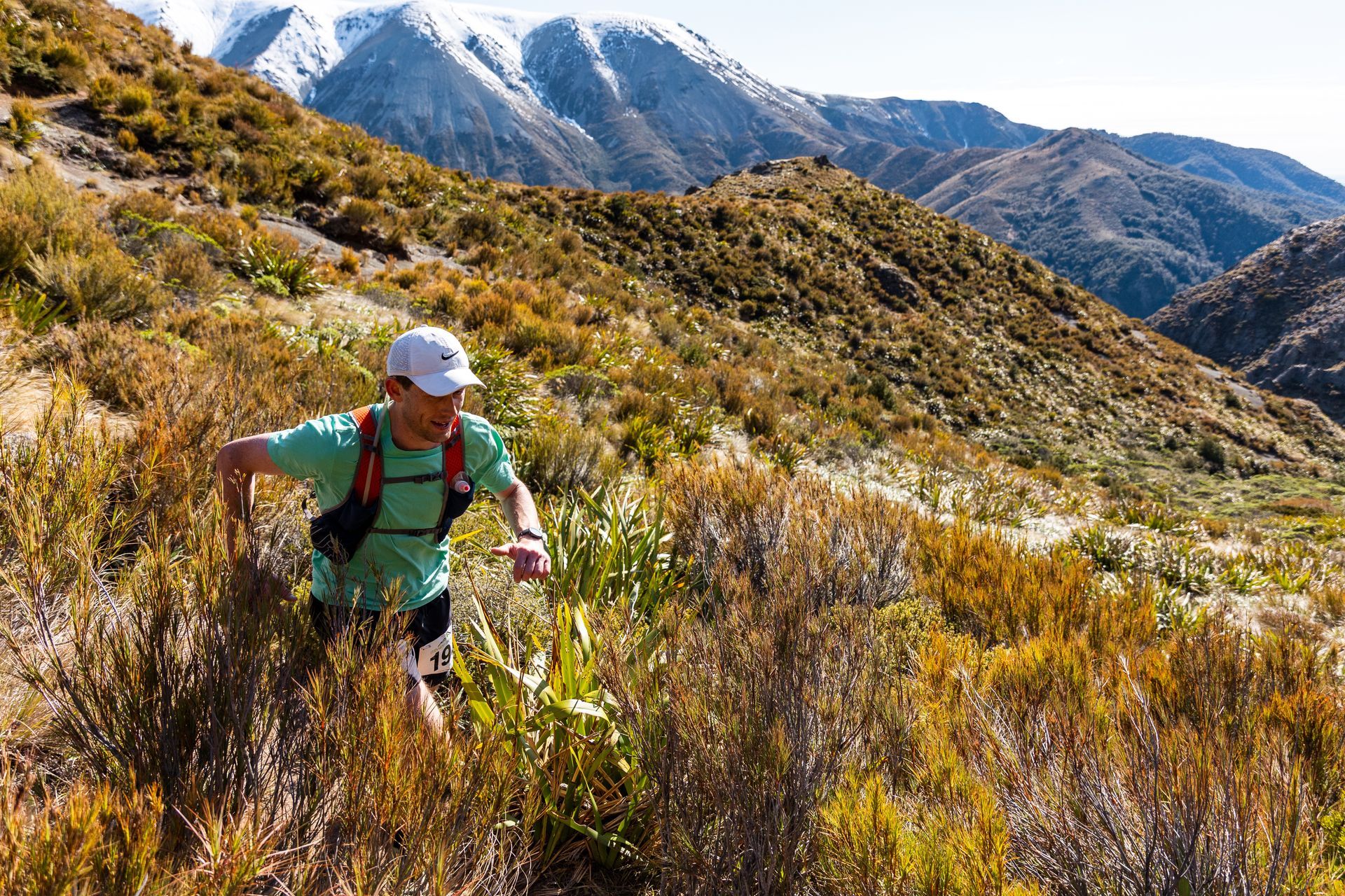 A person is hiking up a hill in the mountains.