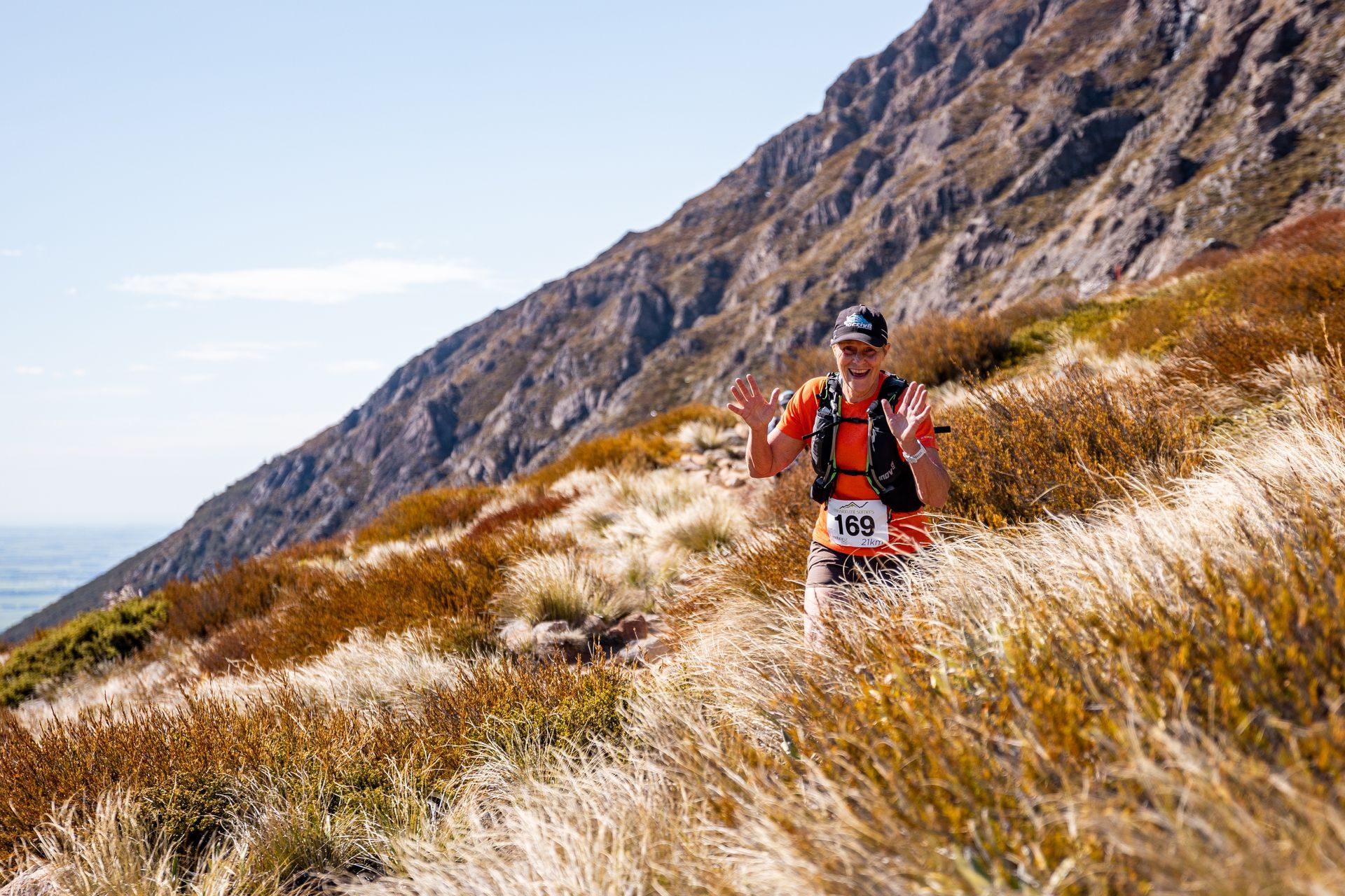 A man is running on a trail in the mountains.