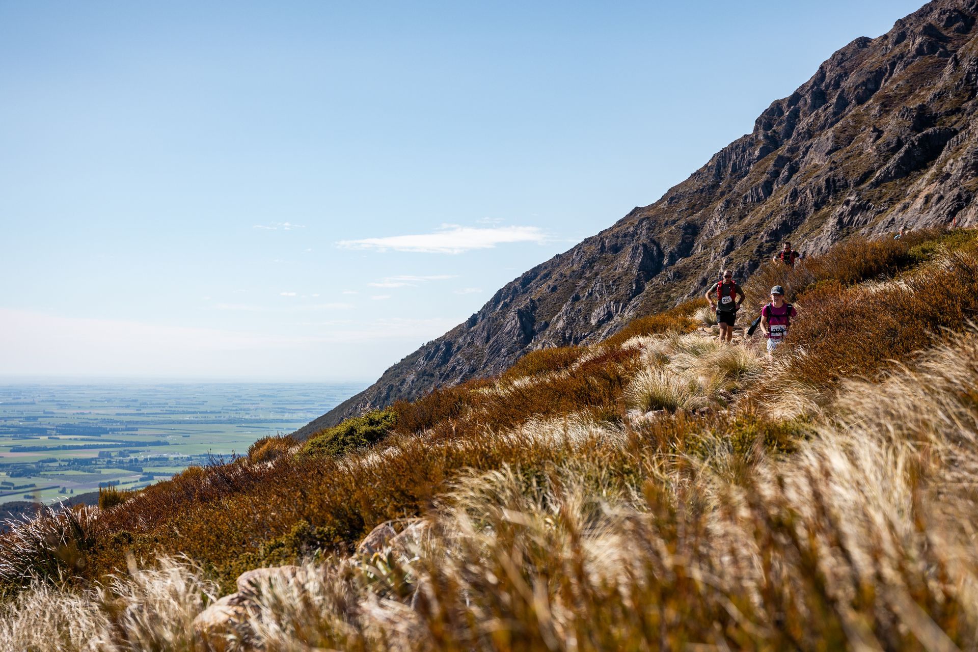 A couple of people are running up a hill.