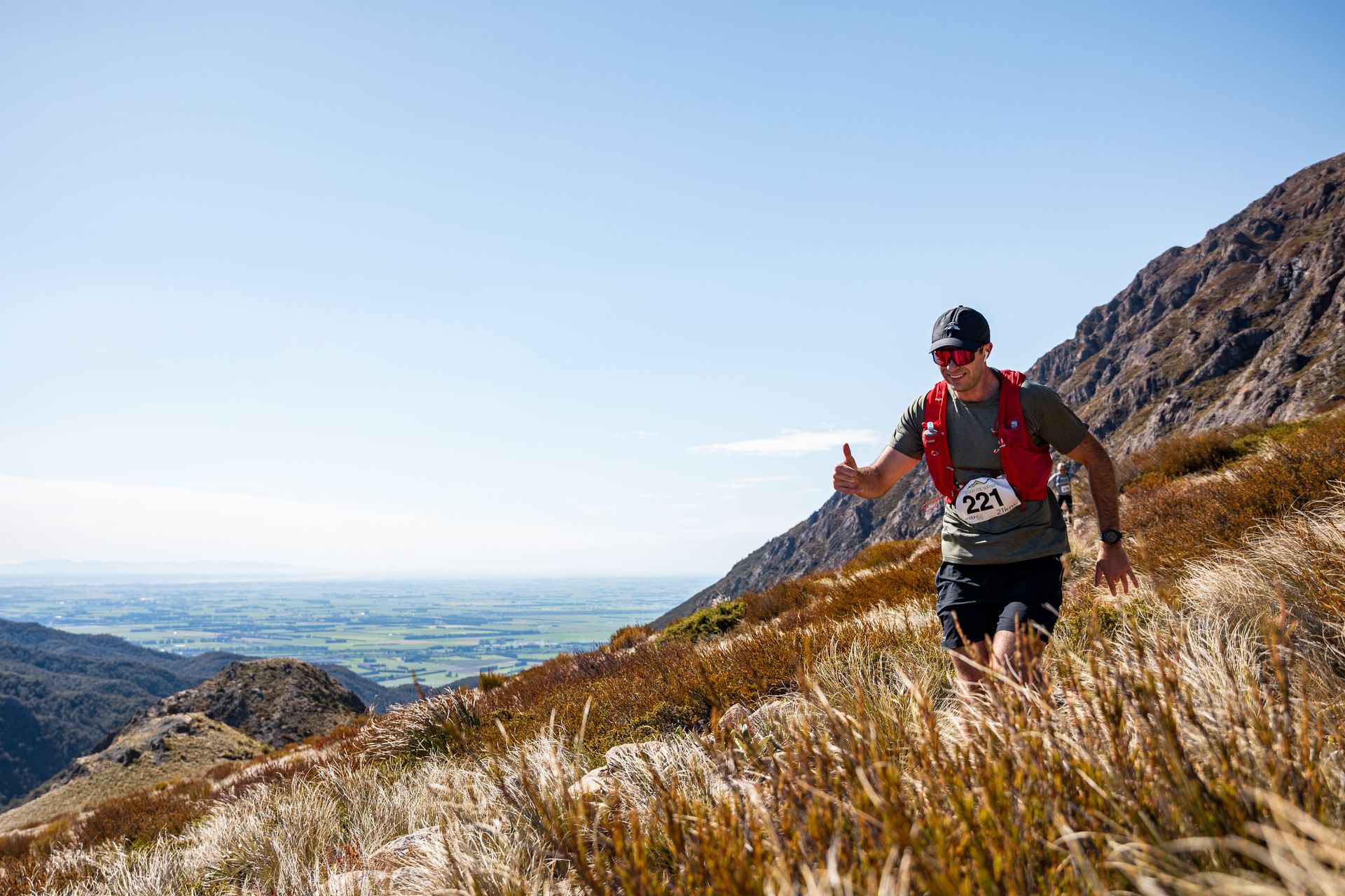 A man is running up a hill in the mountains.