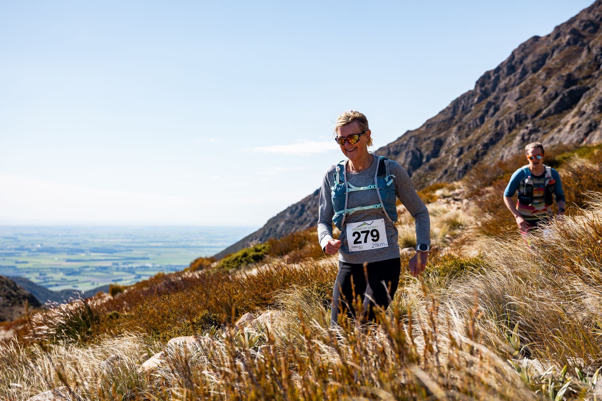 A man and a woman are running up a hill.