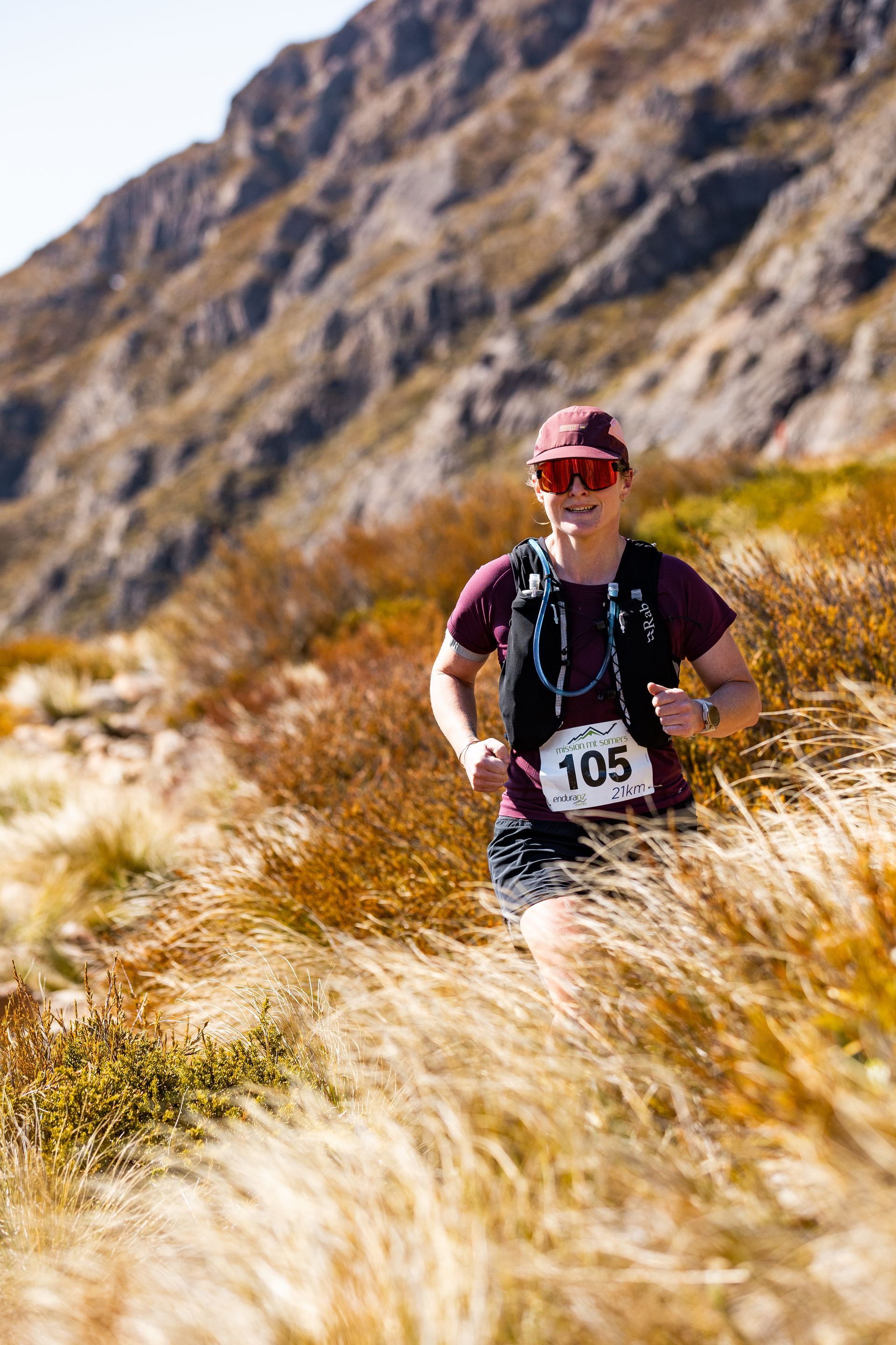 A man is running through a field of tall grass.