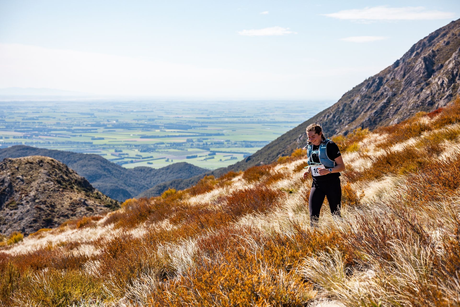 A man is running up a hill in the mountains.