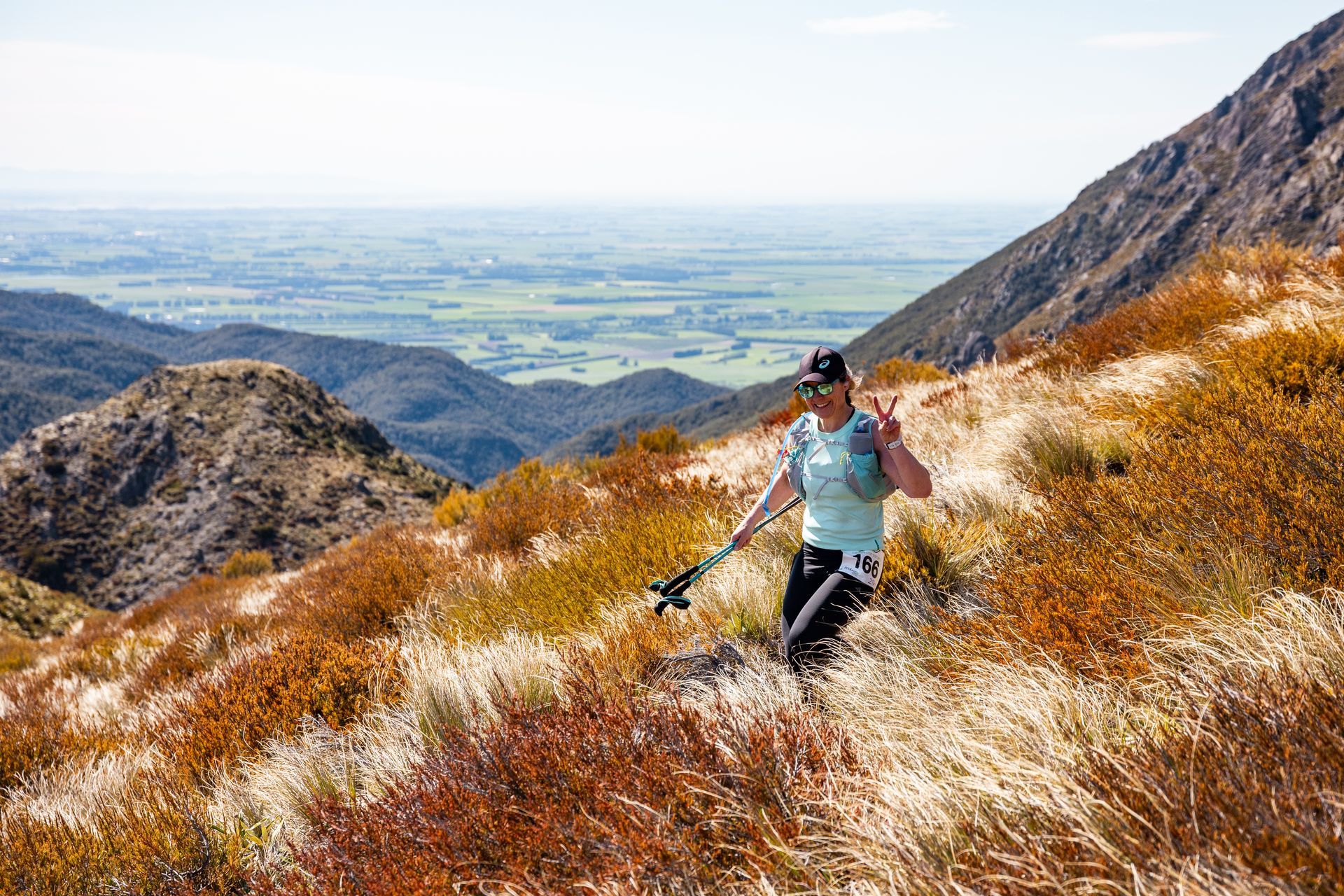 A man is hiking up a hill in the mountains.
