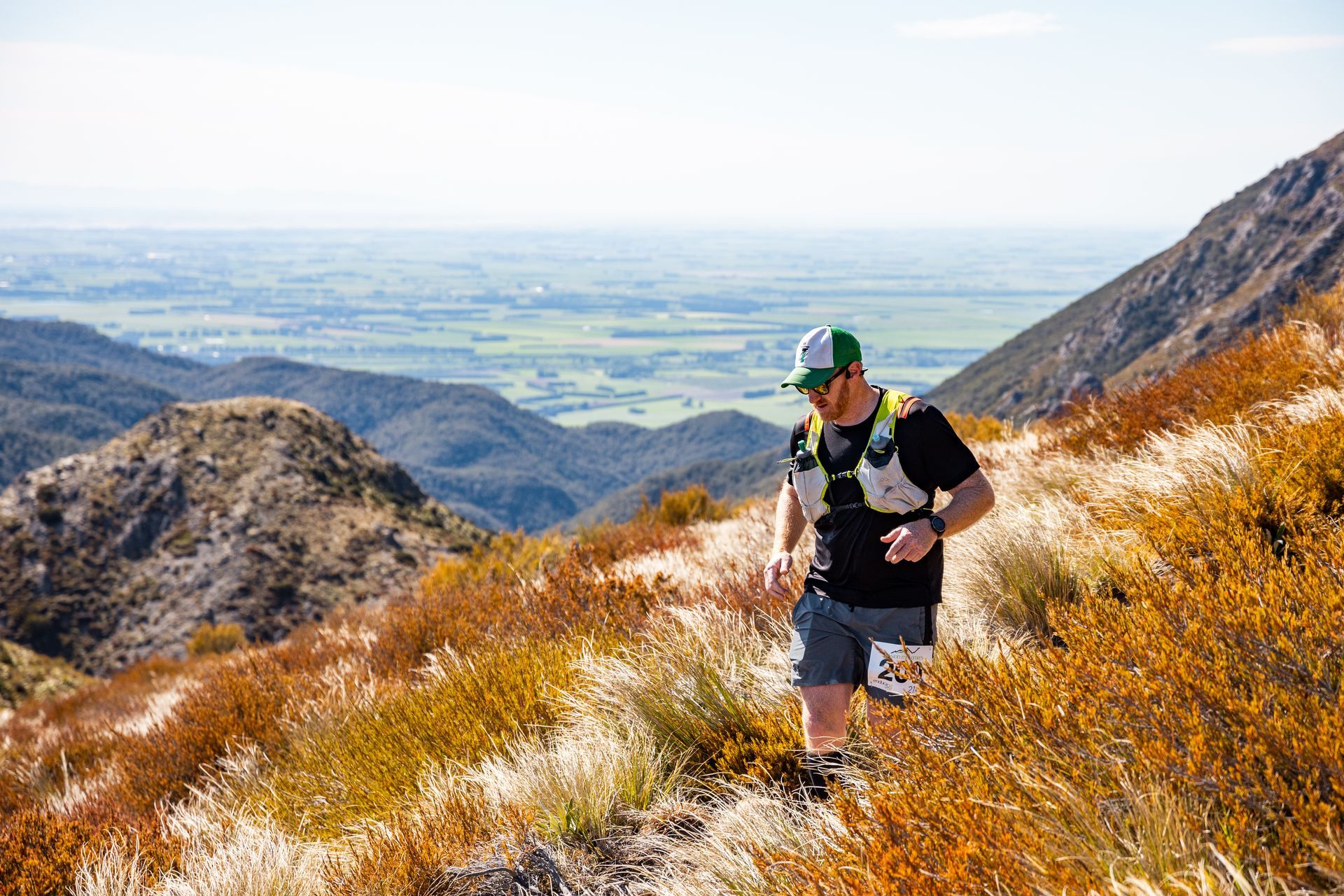 A man is walking up a hill in the mountains.