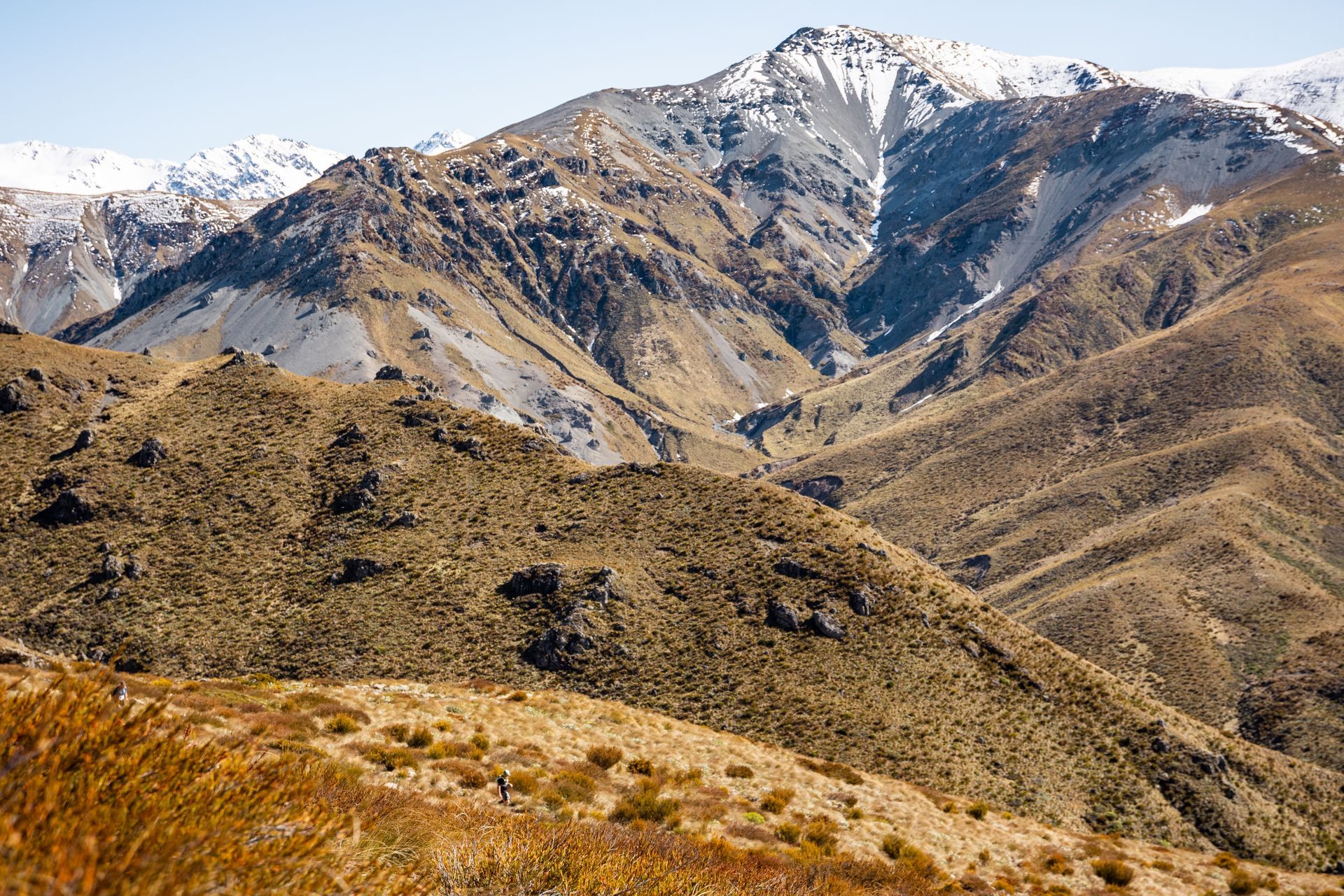 A mountain range with snow on the peaks and valleys