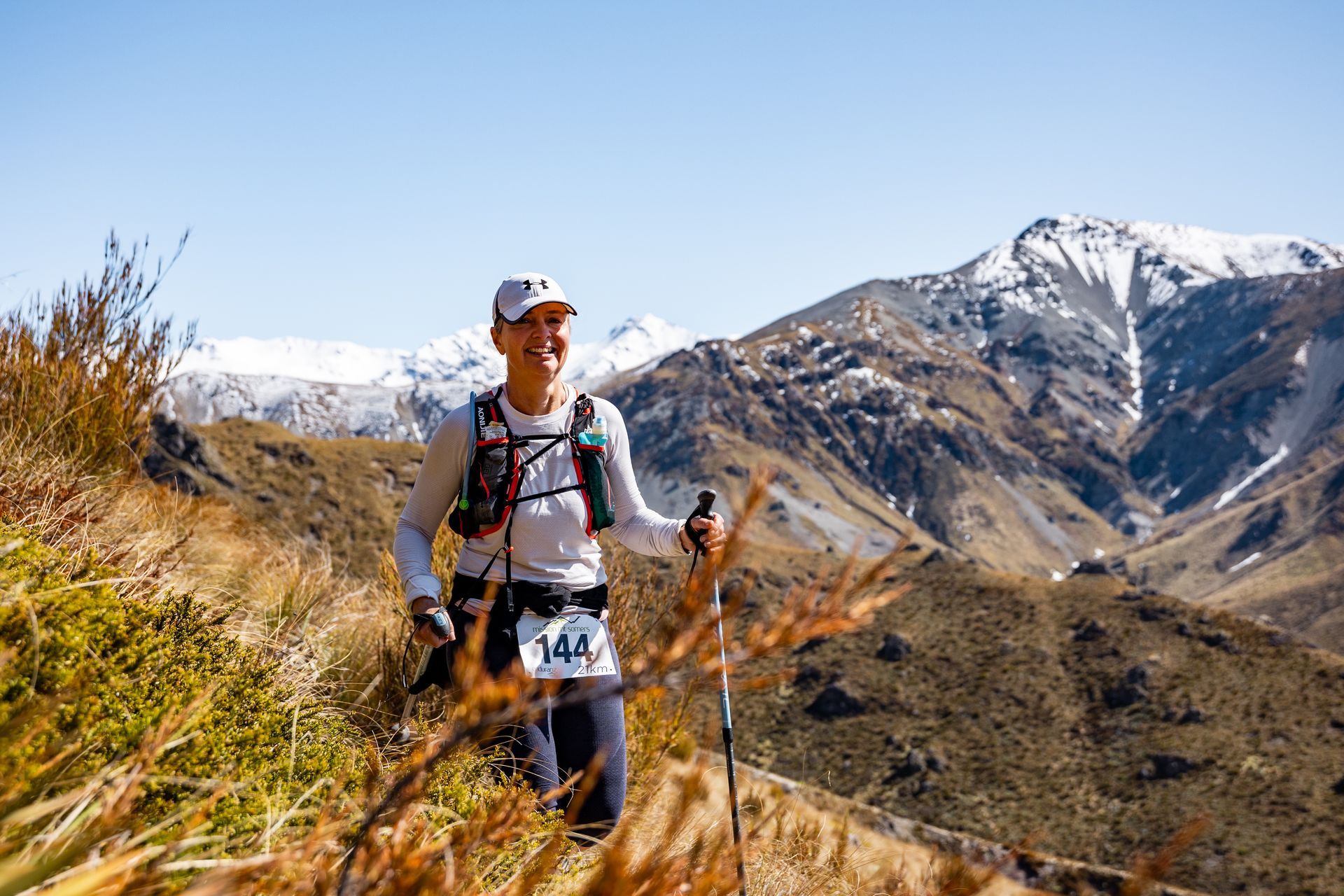 A man is running on a trail in the mountains.