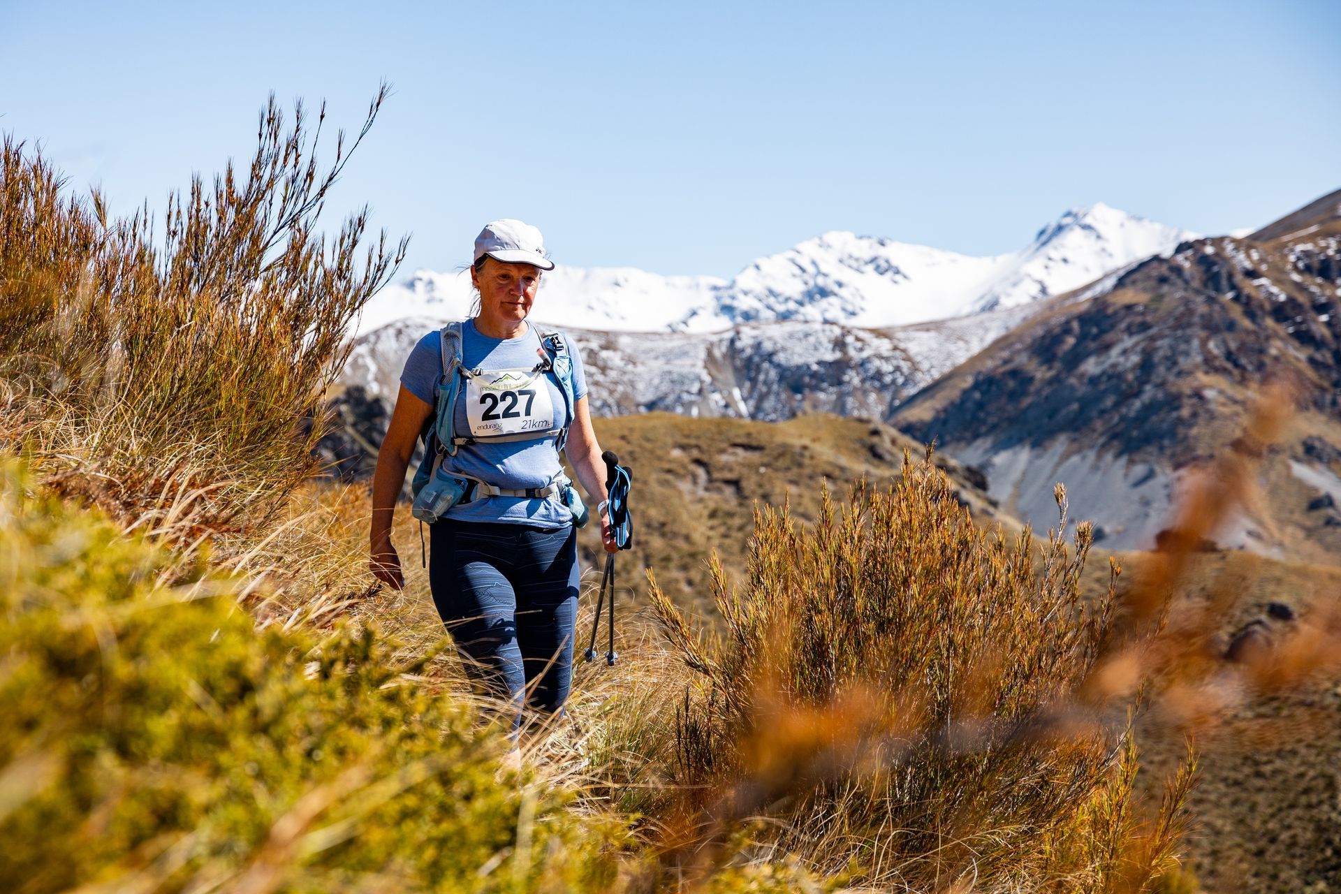 A woman is walking on a trail in the mountains.