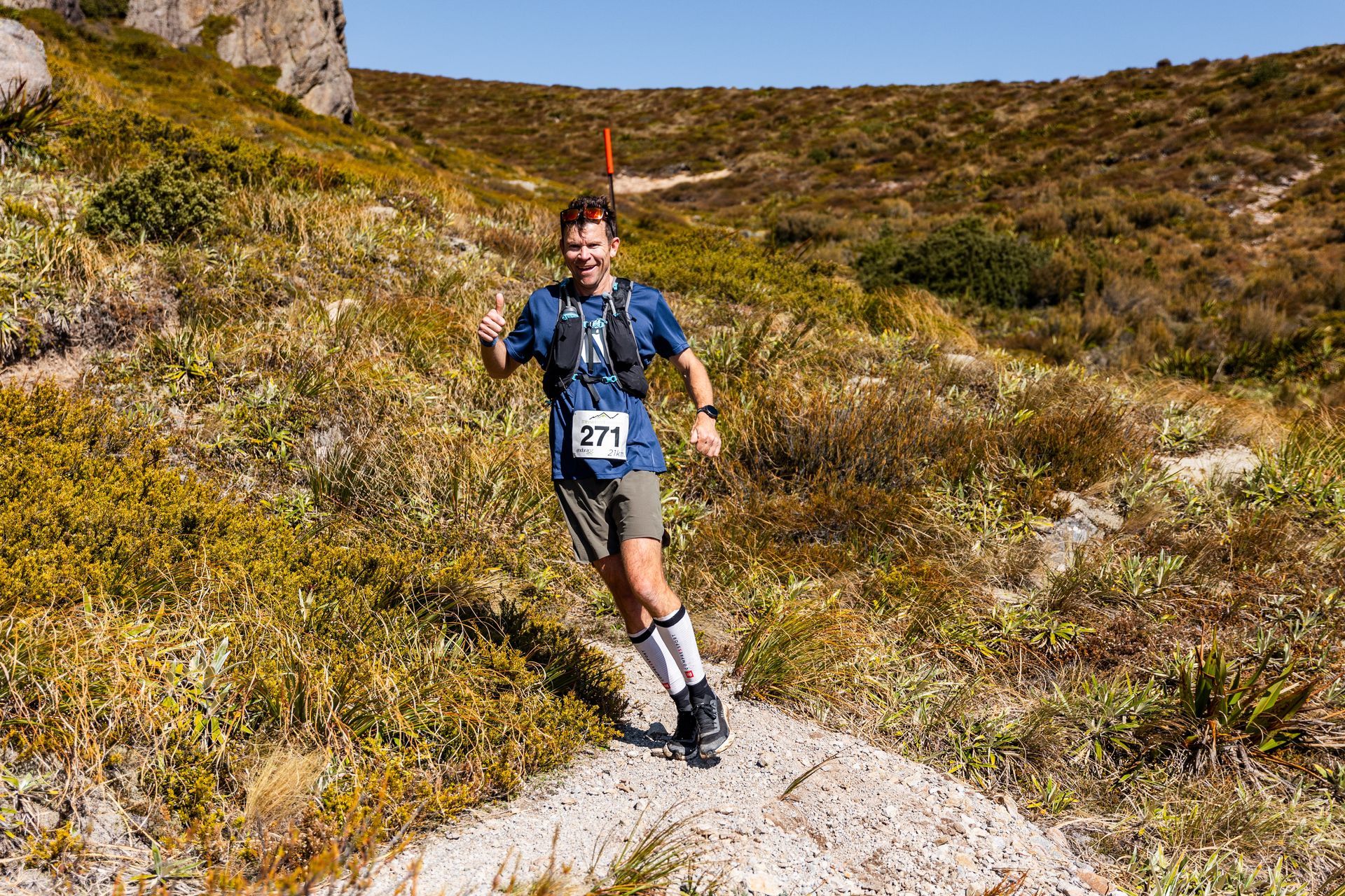 A man is running on a trail in the mountains.