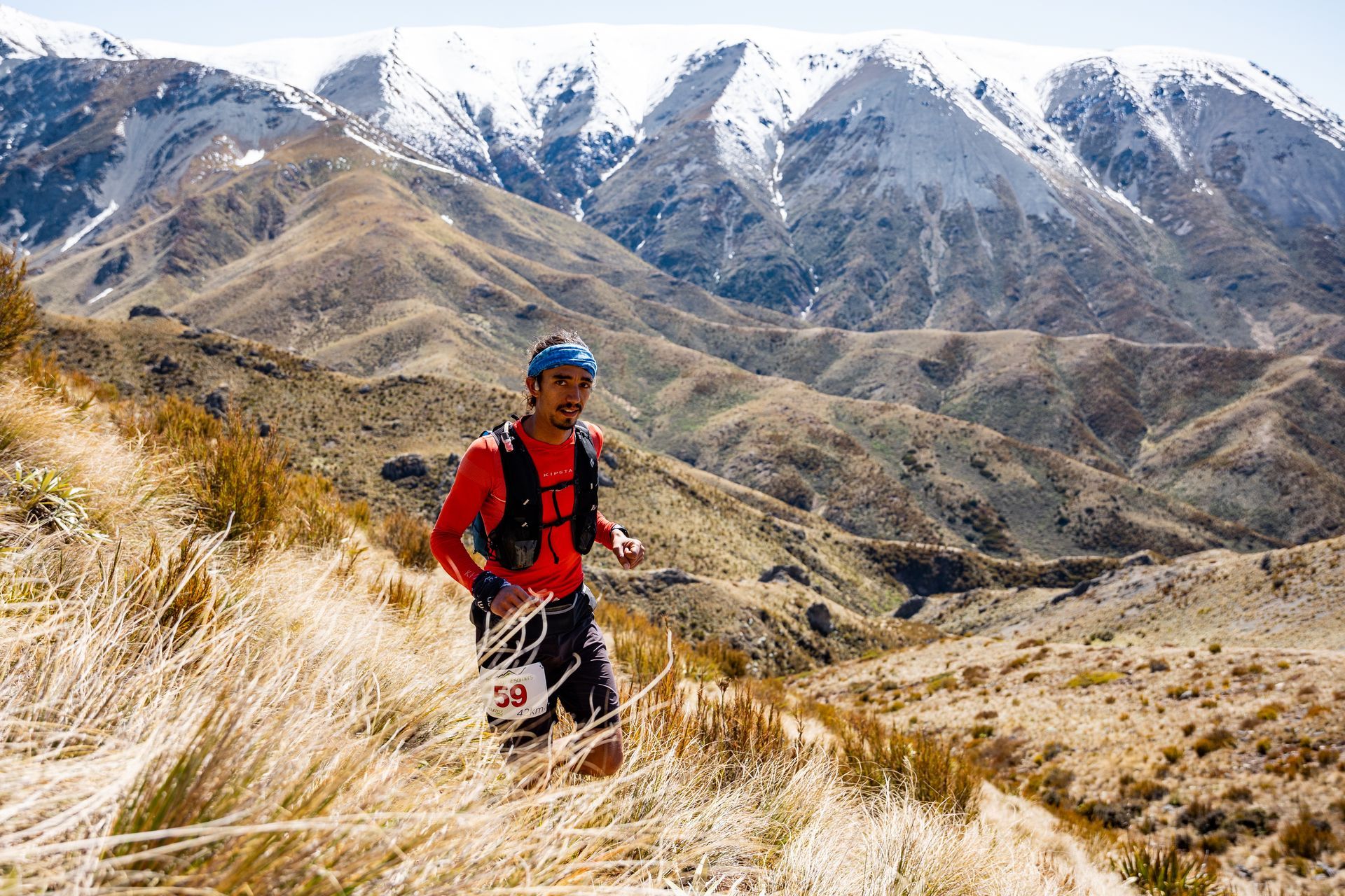 A man is running on a trail in the mountains.