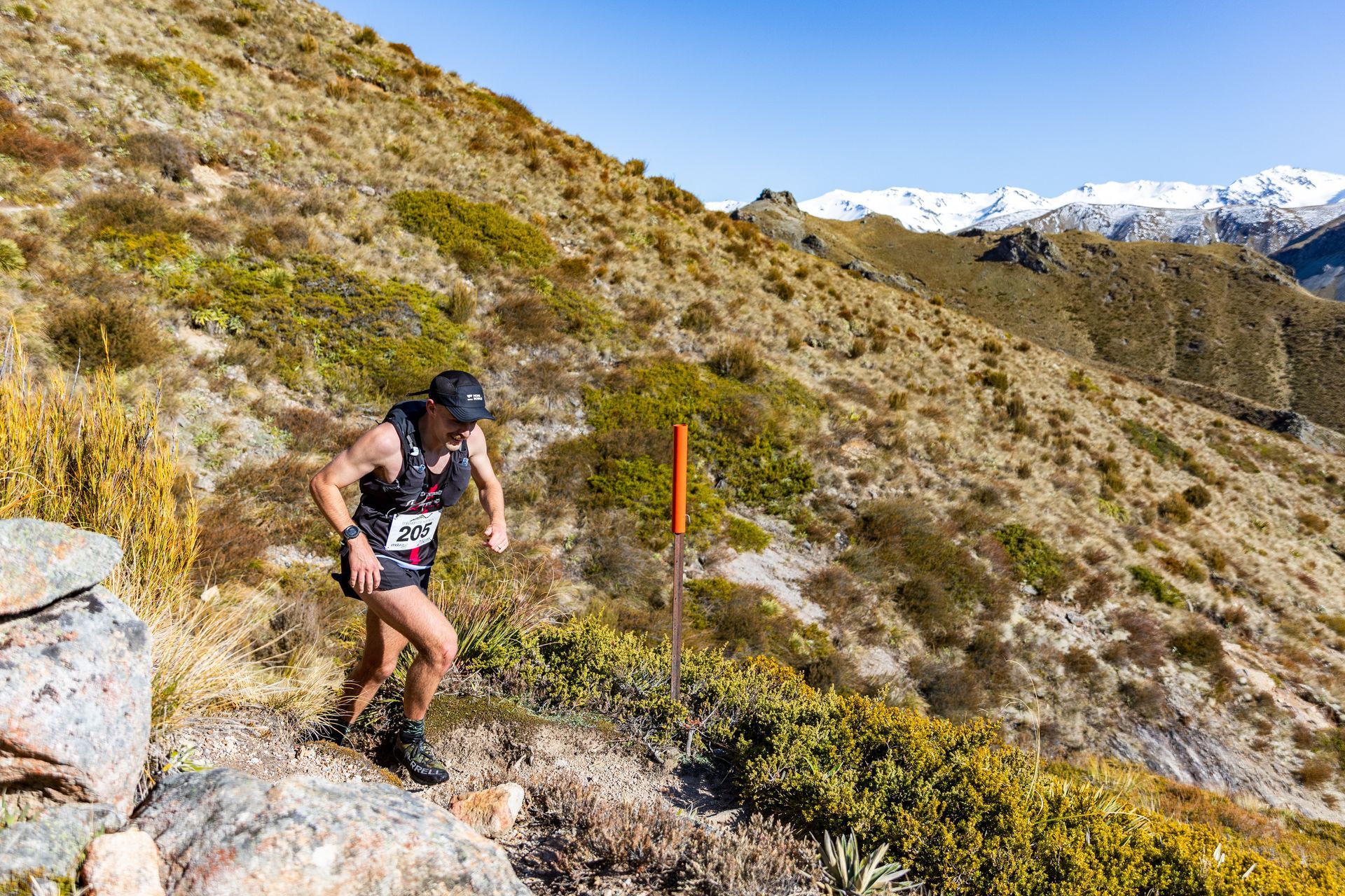 A man is running up a hill in the mountains.
