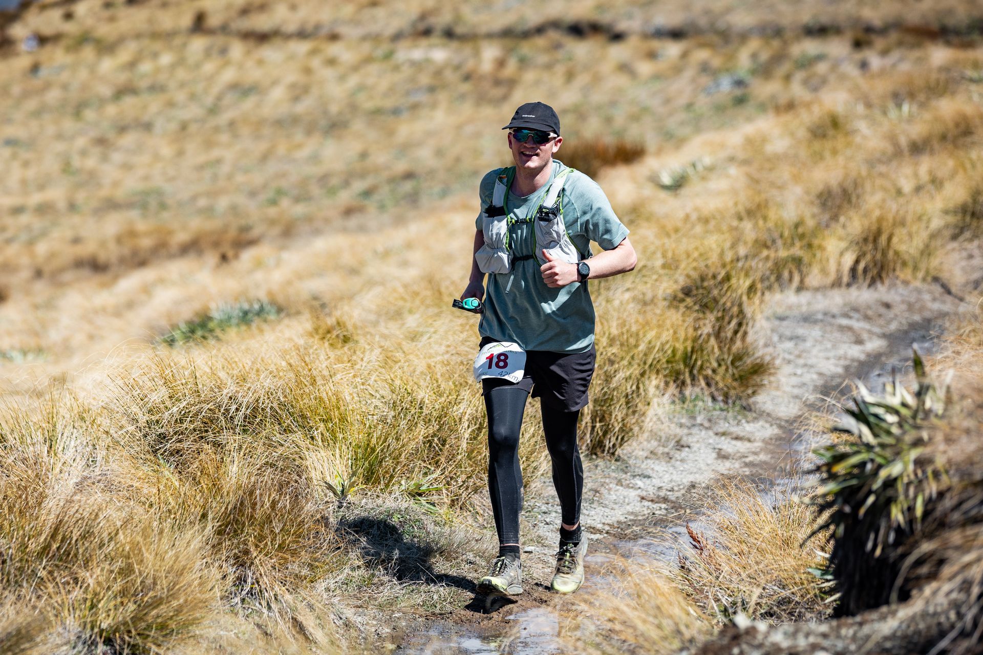 A man is running on a trail in a field.