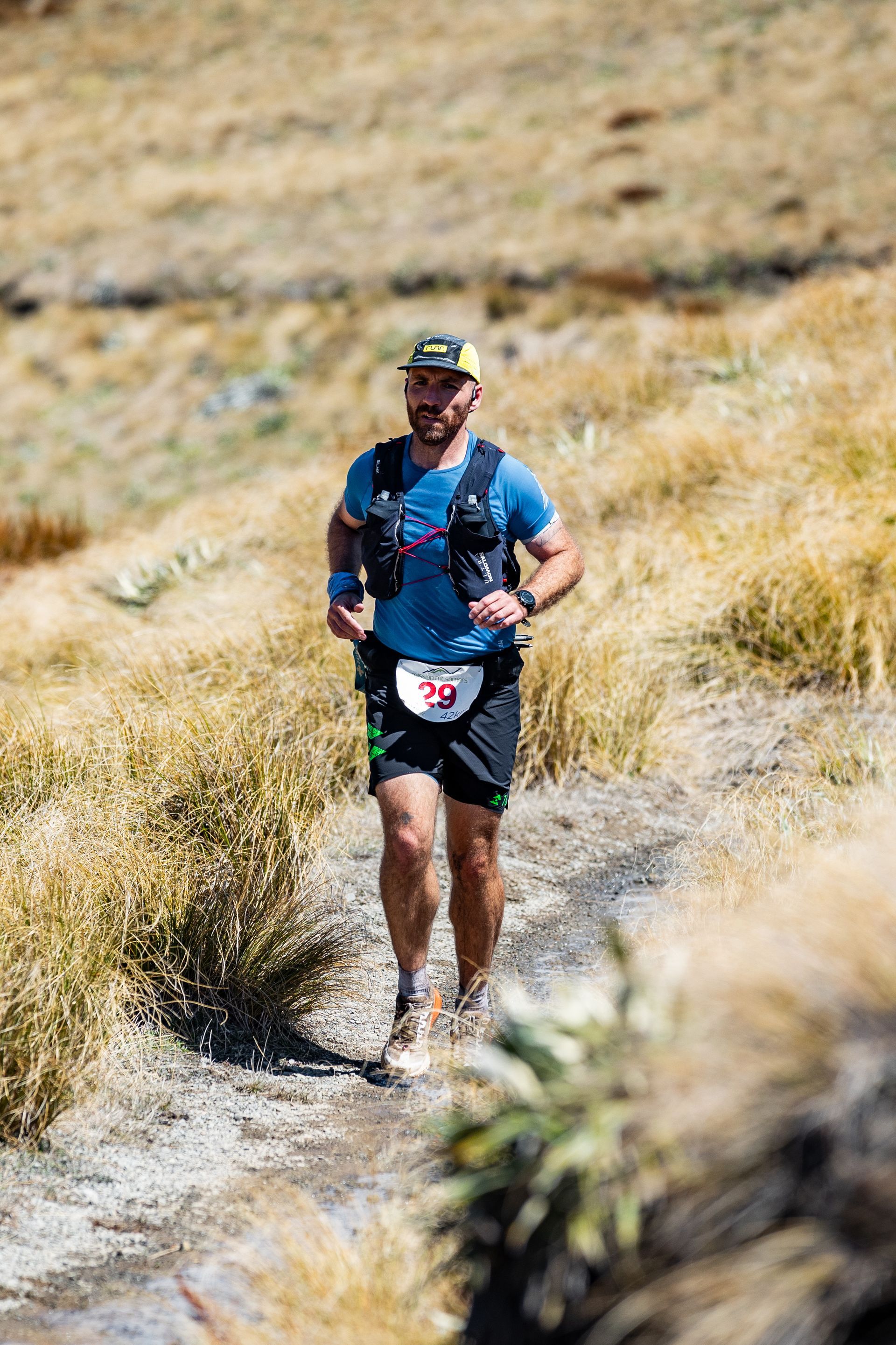 A man is running on a trail in the desert.