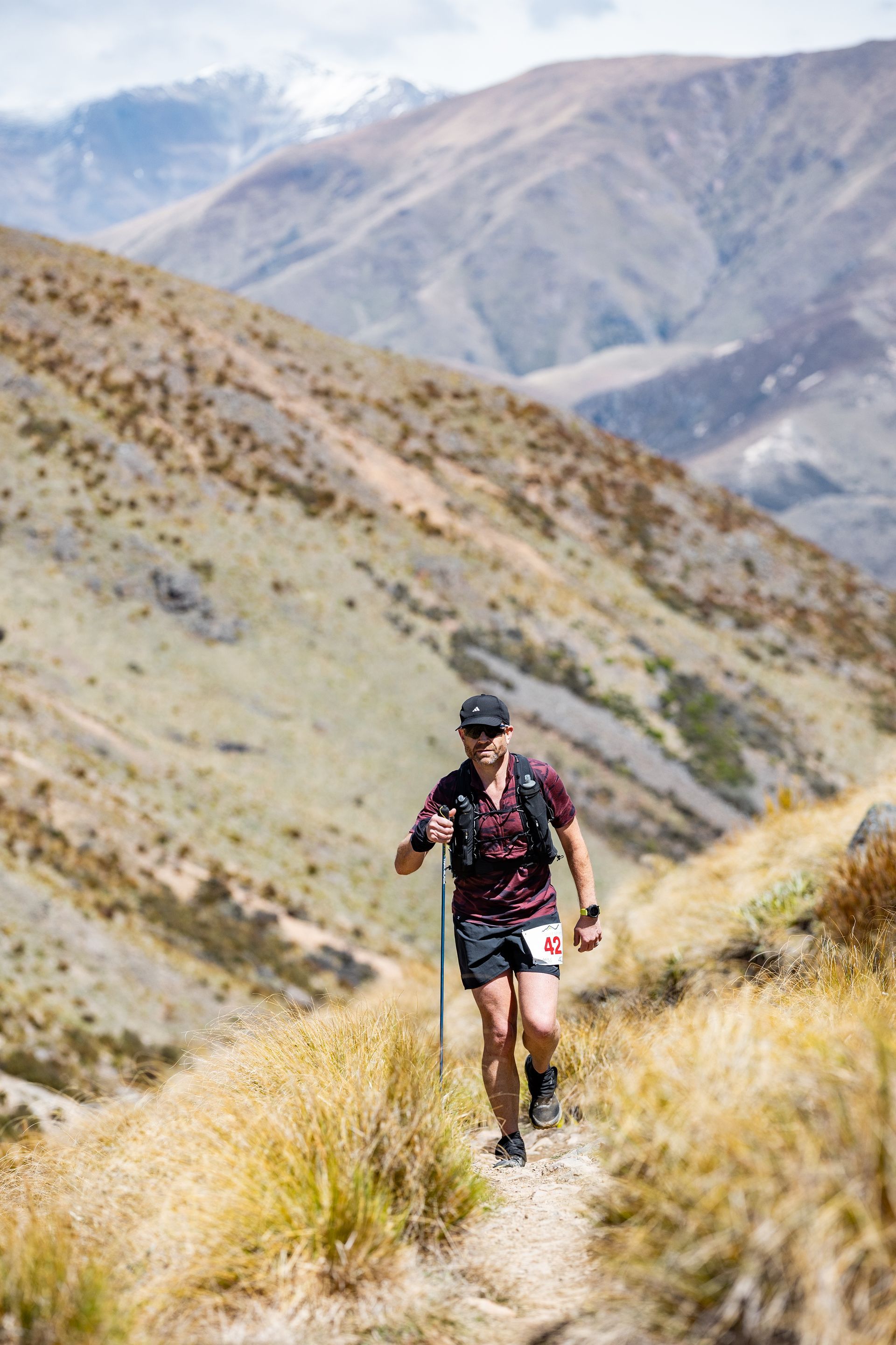 A person is walking down a trail in the mountains.