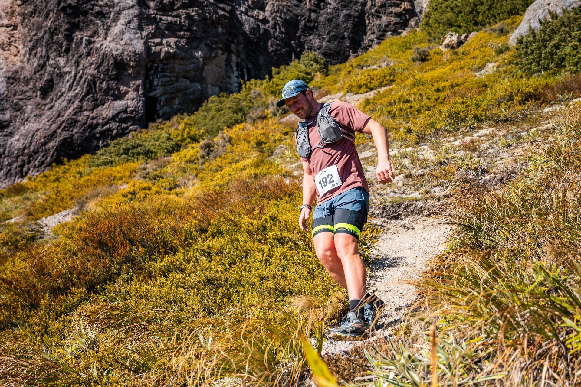 A man is running up a hill on a trail.