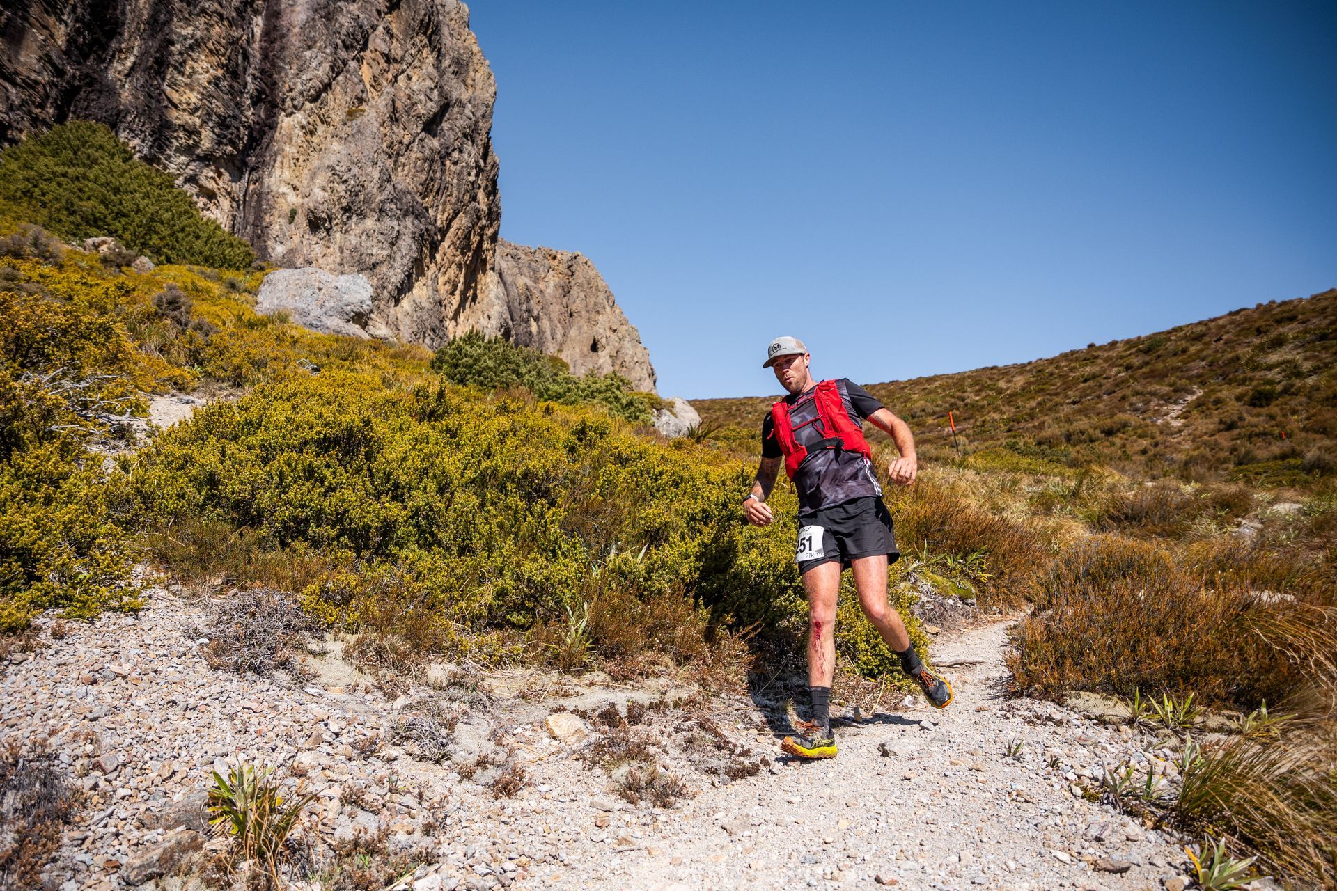 A man is running on a dirt path in the mountains.