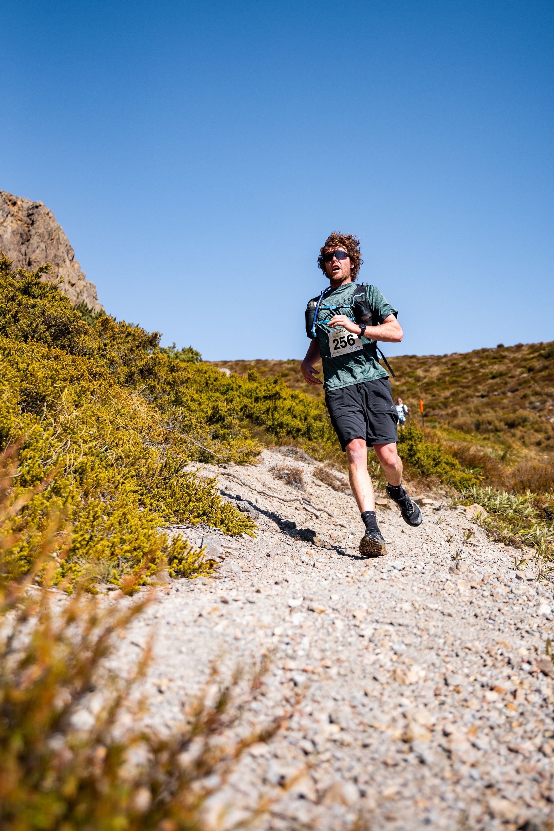 A man is running on a dirt road in the mountains.