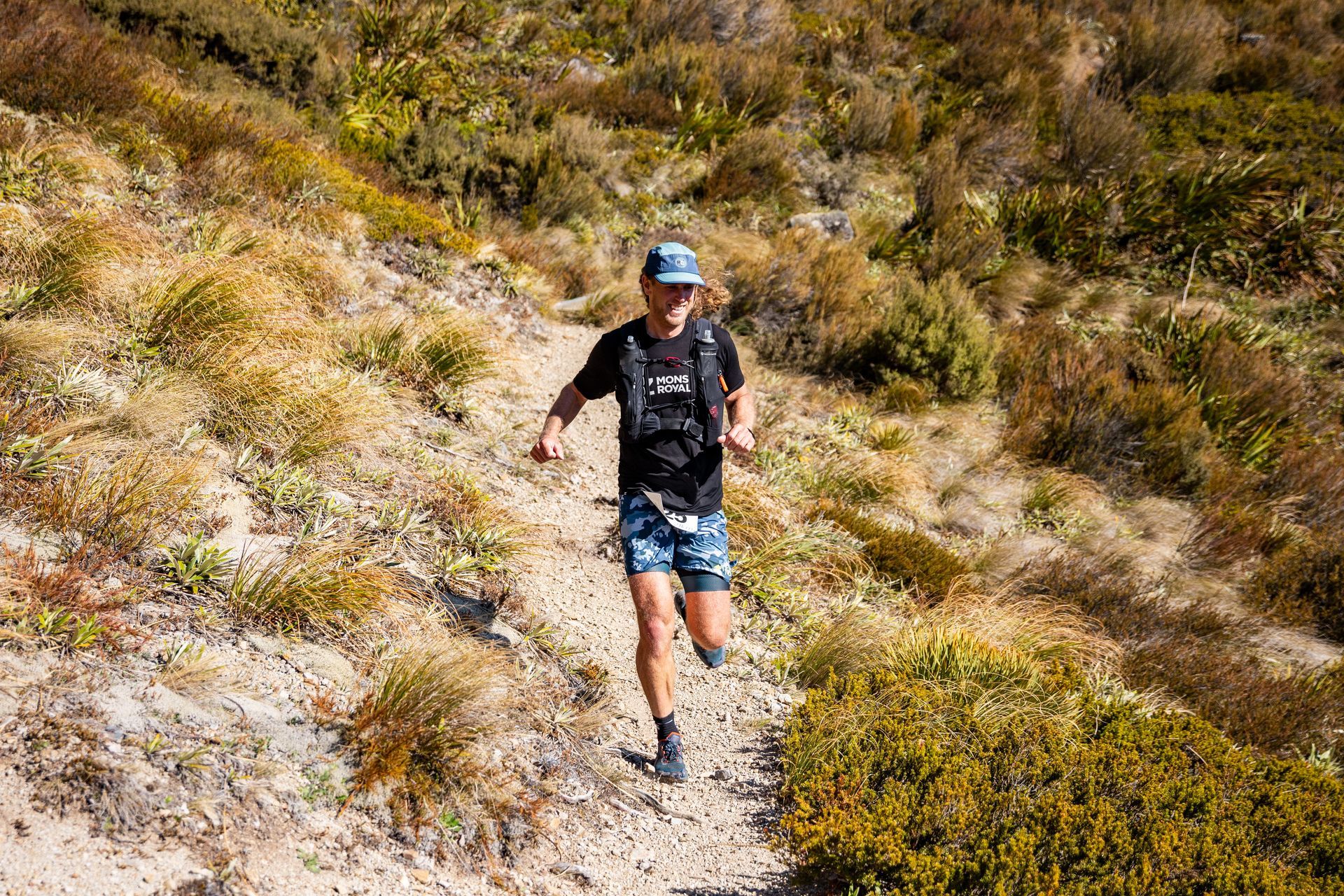 A man is running down a dirt path in the woods.