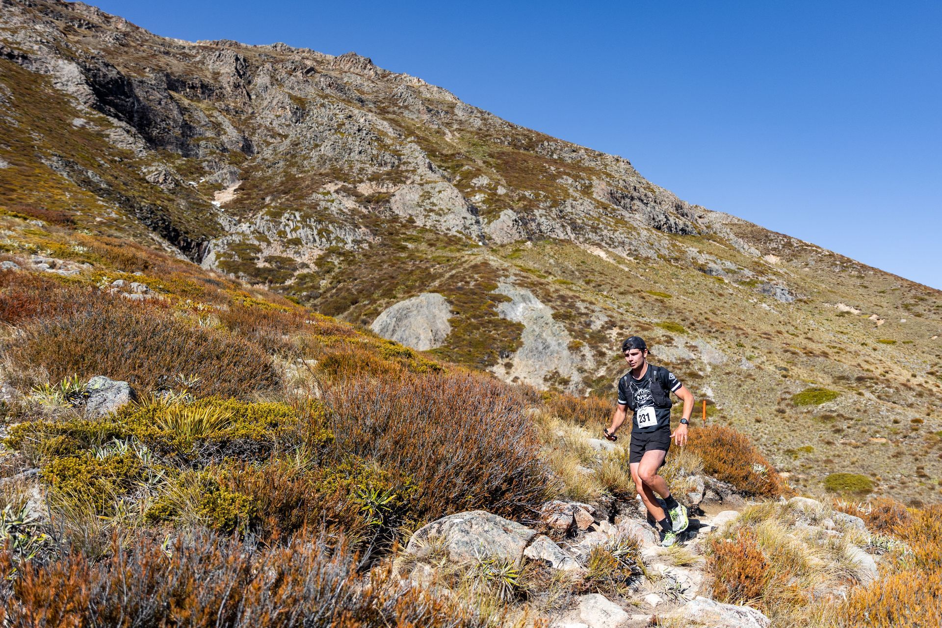 A man is running up a hill on a trail.